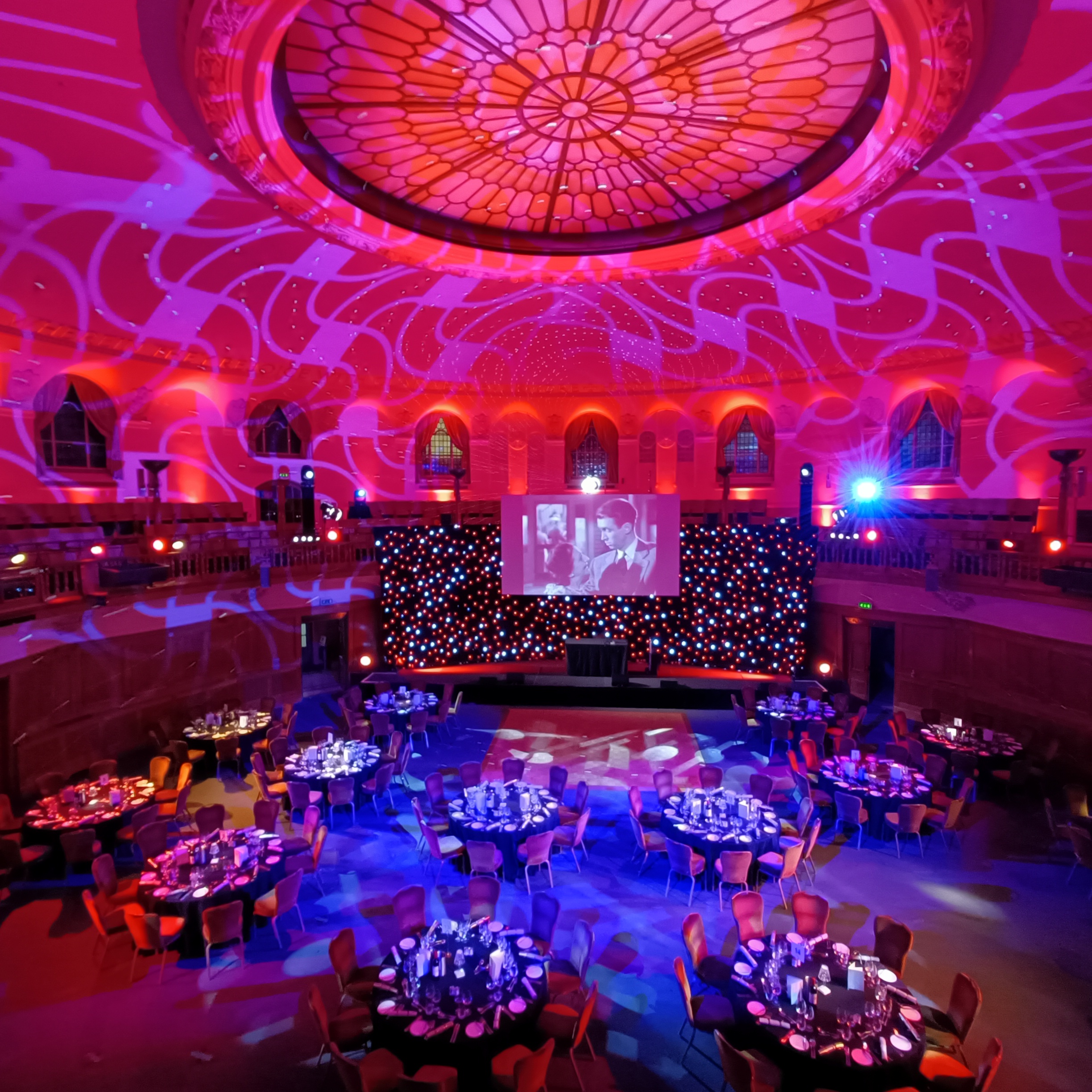 Christmas gala at Church House Westminster with elegant round tables and vibrant lighting.