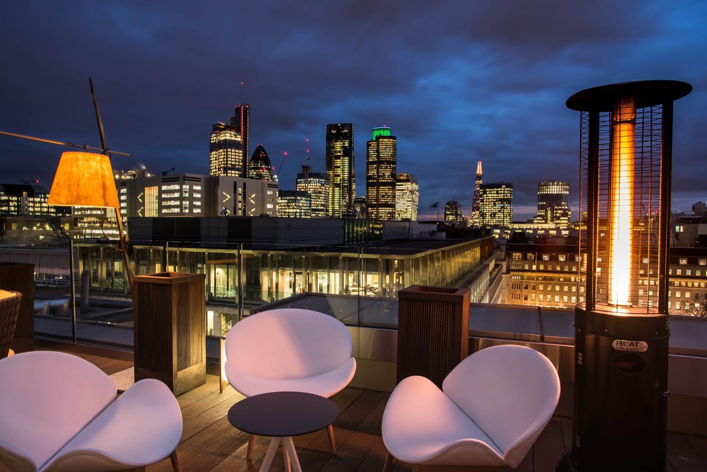 Rooftop venue with skyline view, modern seating for evening events and gatherings.