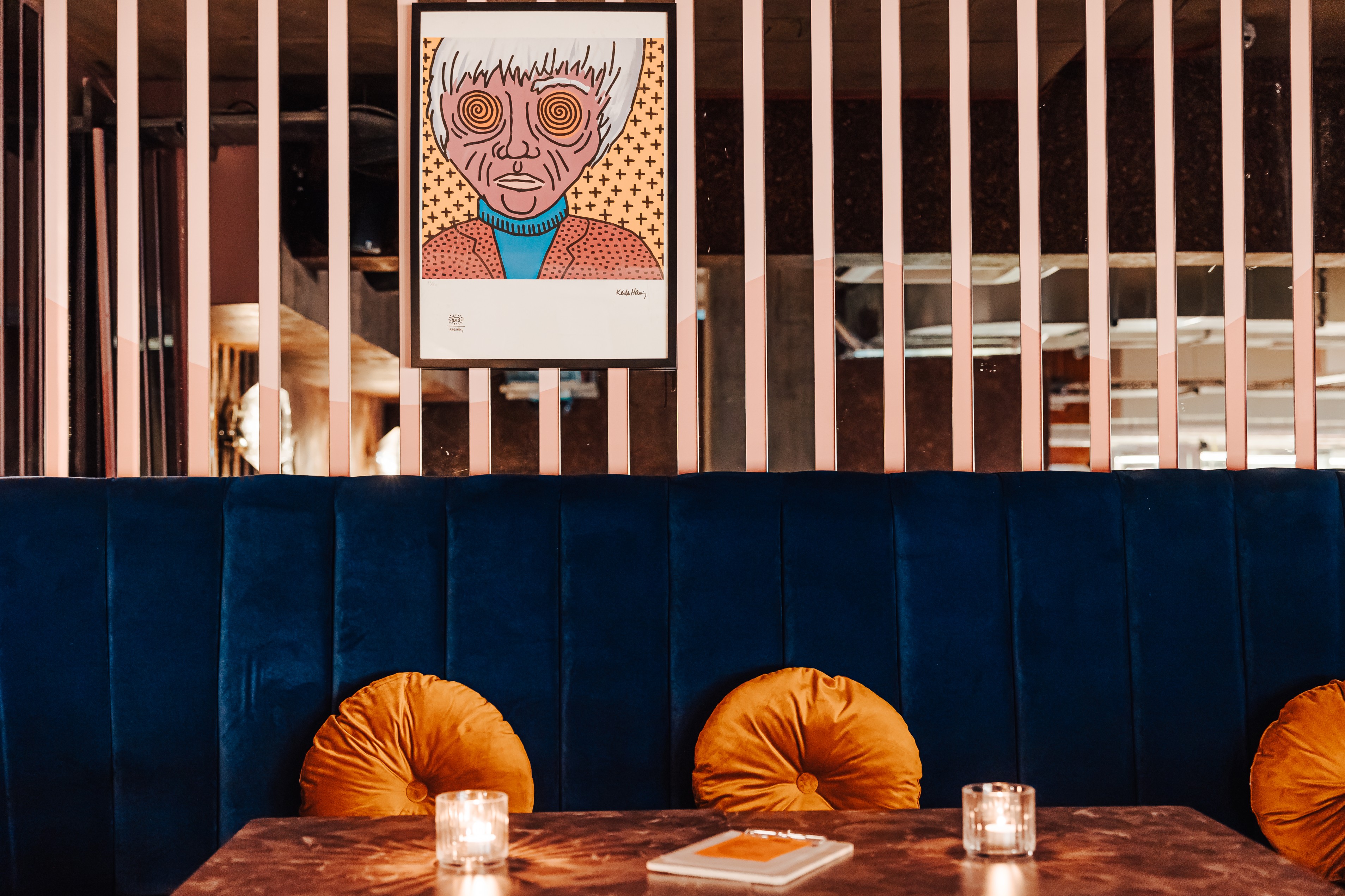 Stylish Mezzanine meeting space with plush blue banquette, ideal for gatherings and brainstorming.