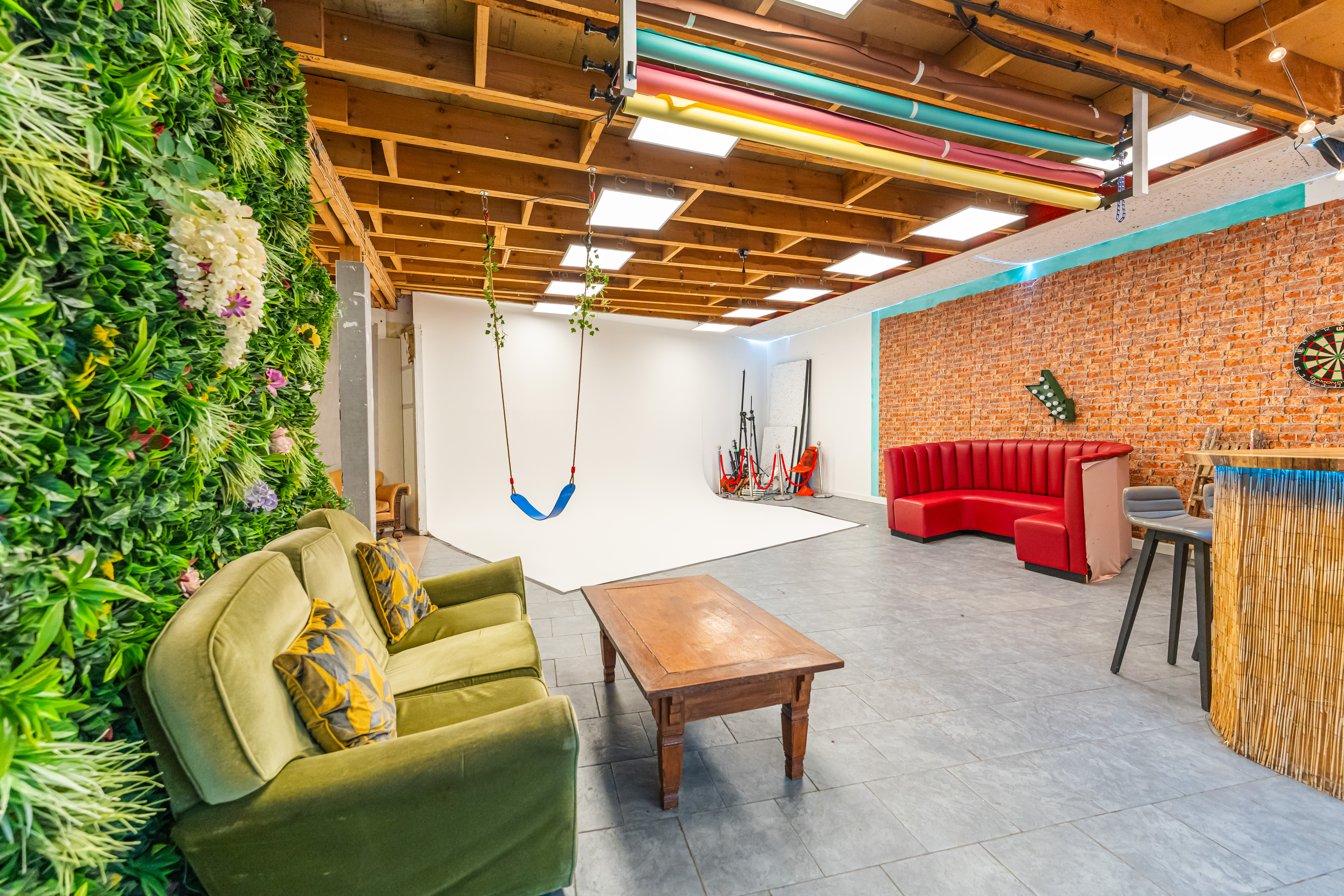 Versatile event space at 6 Degrees Studios with vibrant green wall for creative gatherings.