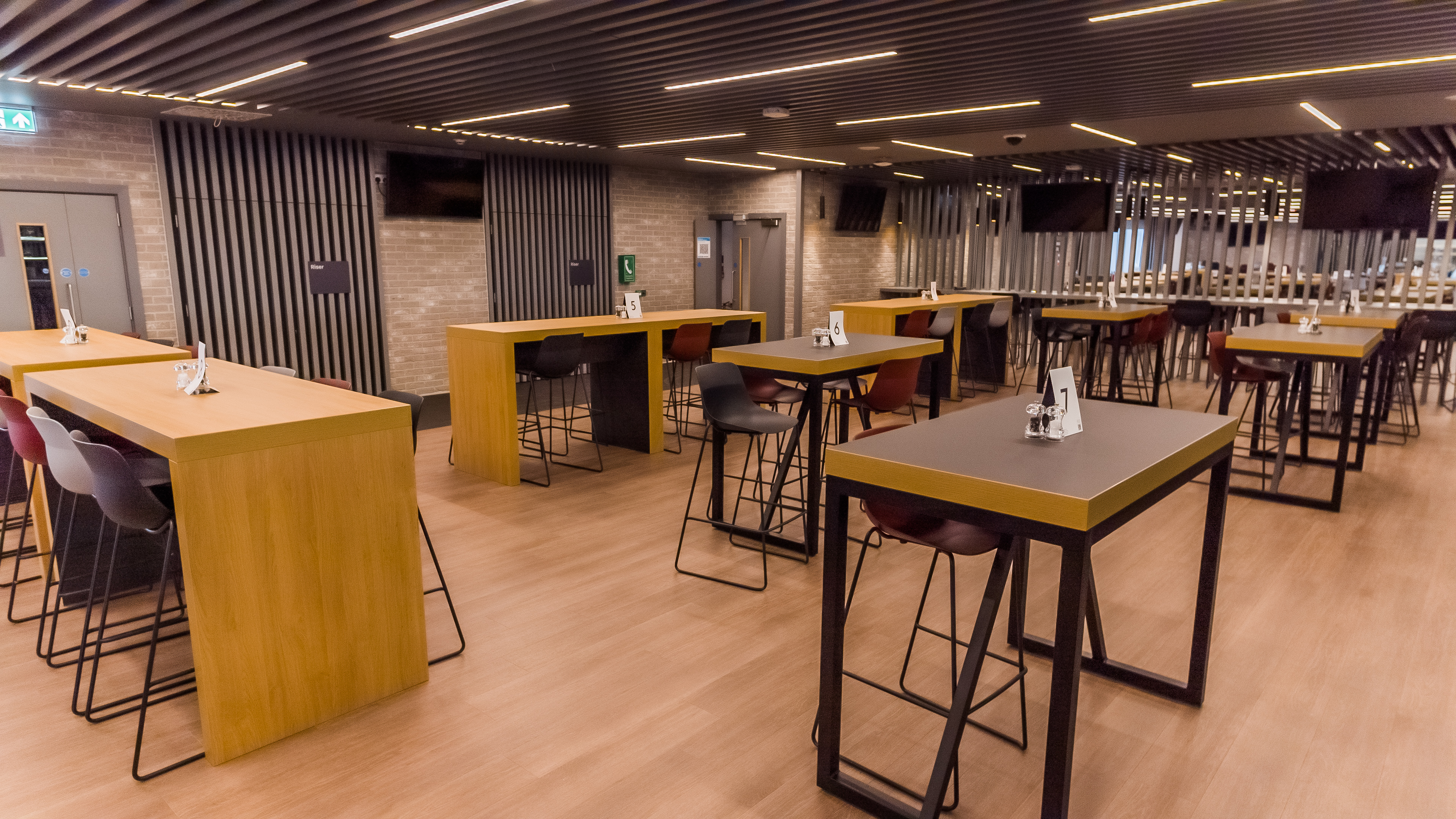 Modern event space at Brentford FC with high-top tables for networking and gatherings.