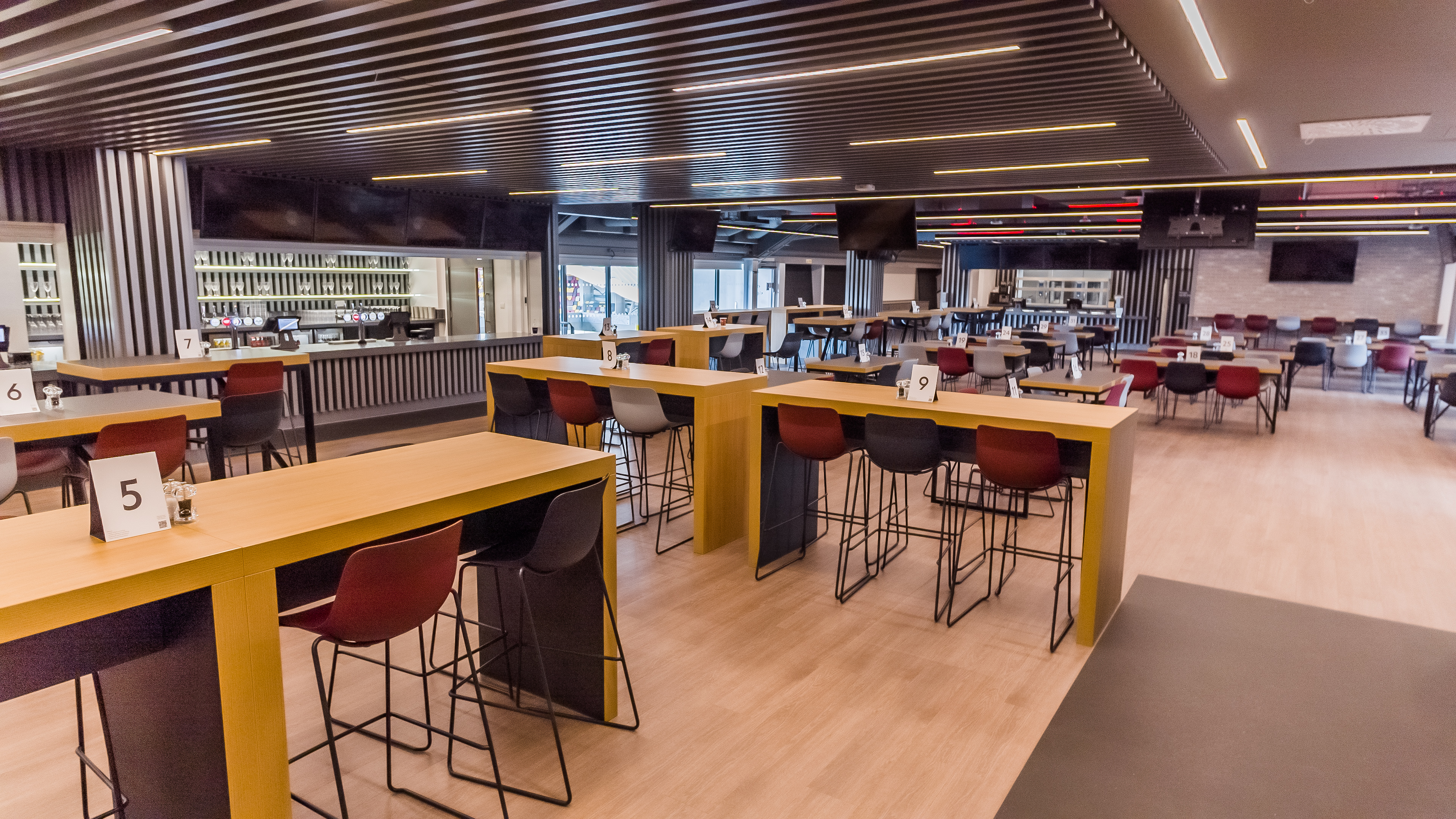 Modern event space at Brentford FC with high tables for networking and meetings.