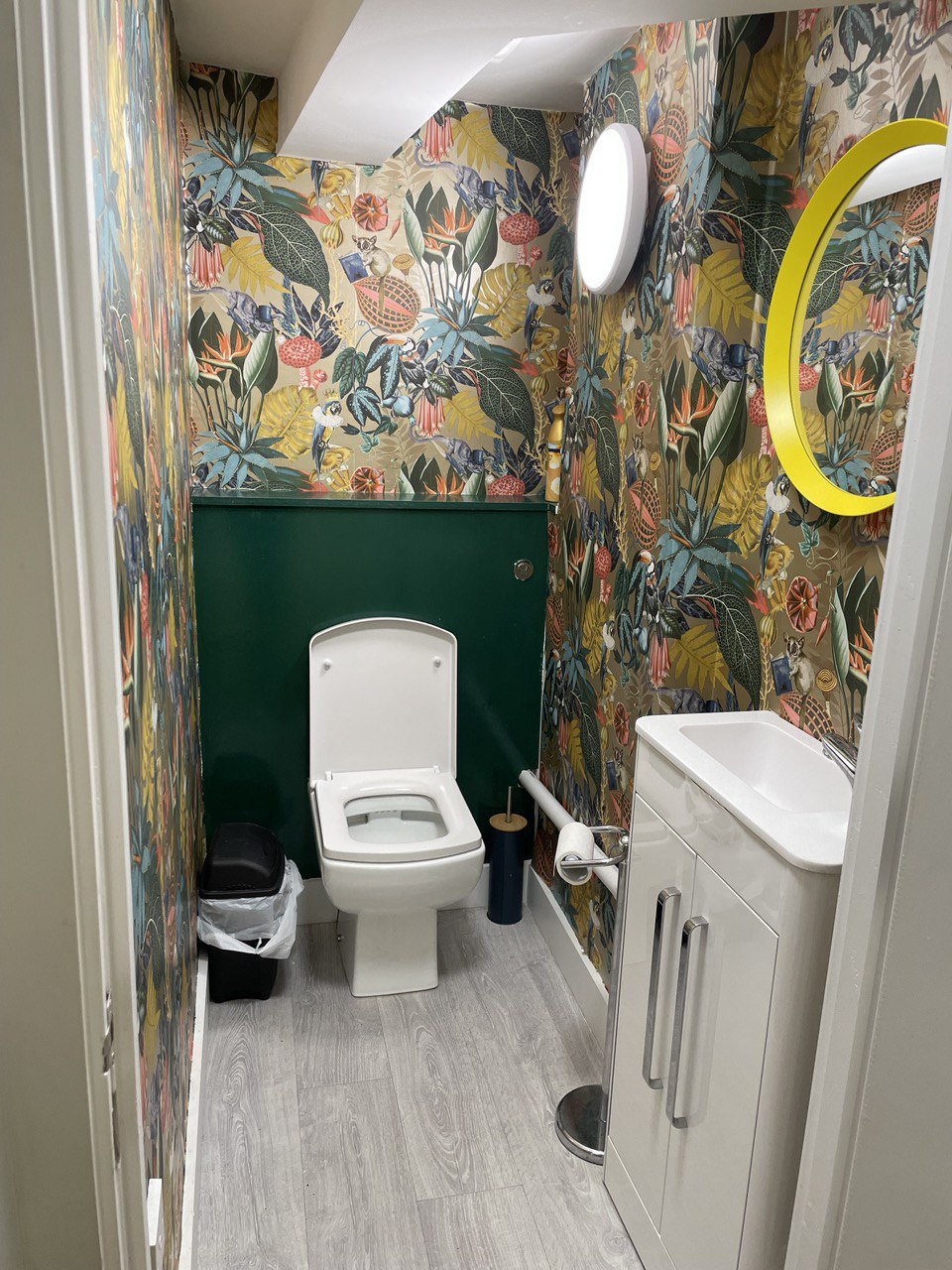 Vibrant restroom at Geo Art Cafe with floral wallpaper, ideal for events and meetings.