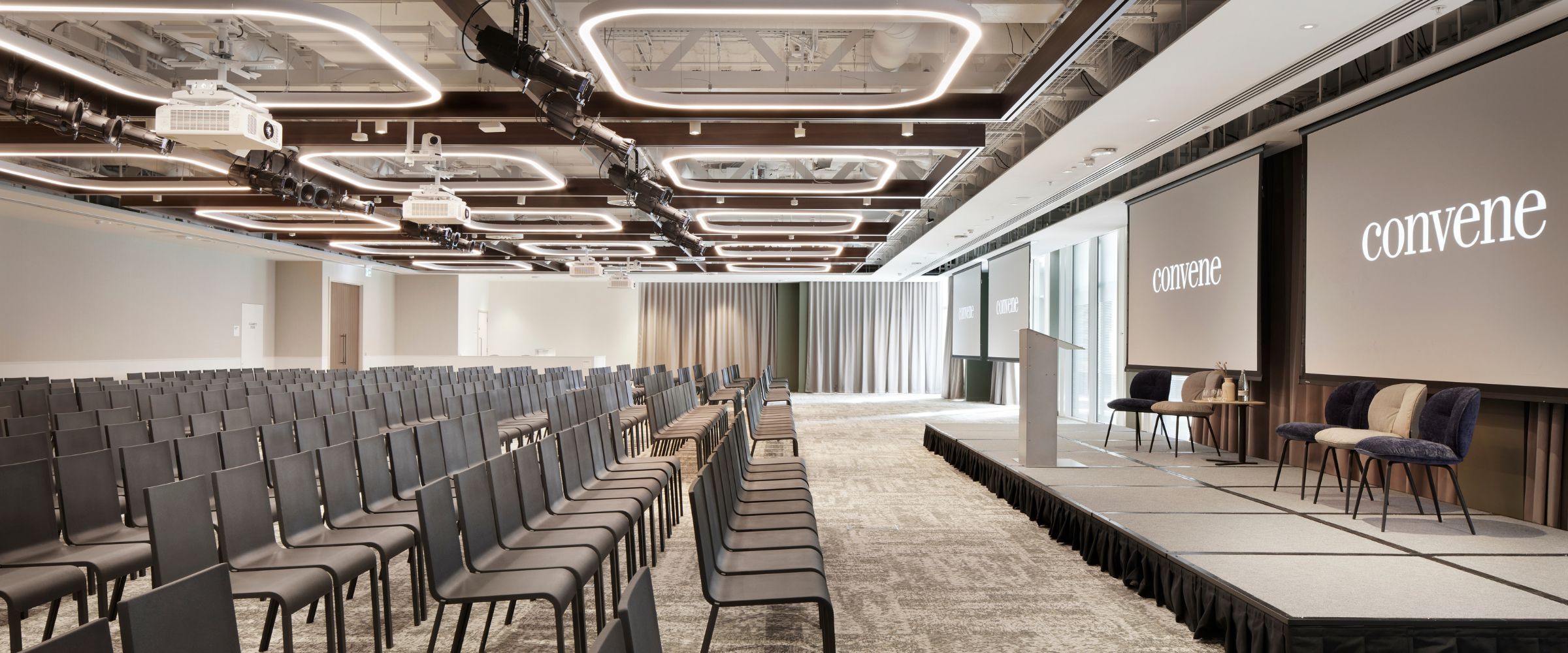 Modern conference venue with sleek chairs and large screen for events in St Pauls.