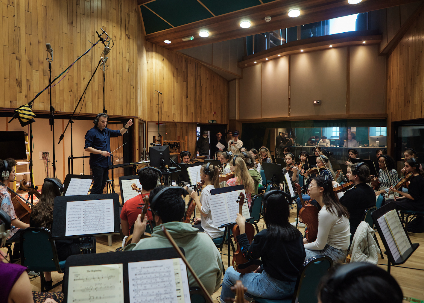 Orchestral rehearsal at Angel Studios showcasing conductor leadership and event planning.