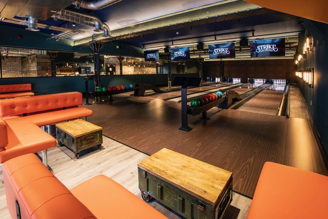 Vibrant bowling alley venue for corporate events with modern decor and seating.