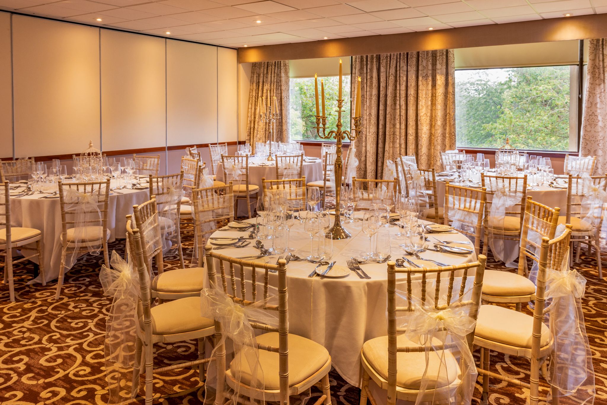 Elegant banquet room with round tables, ideal for weddings and corporate events.
