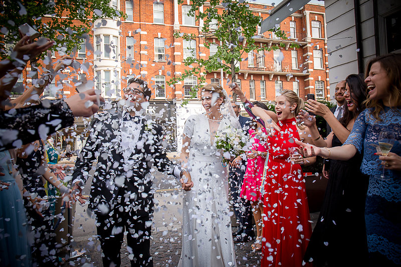 Joyful wedding celebration with confetti at Bluebird Chelsea, highlighting memorable events.