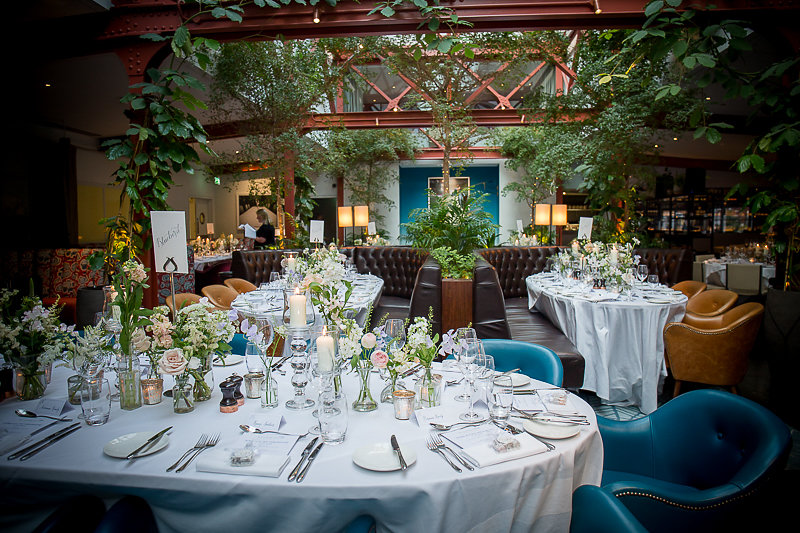 Elegant wedding dining space at Bluebird Chelsea with lush greenery and natural light.