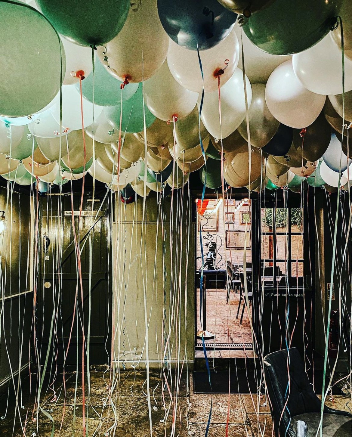 Festive garden room with colorful balloon display for joyful events and gatherings.