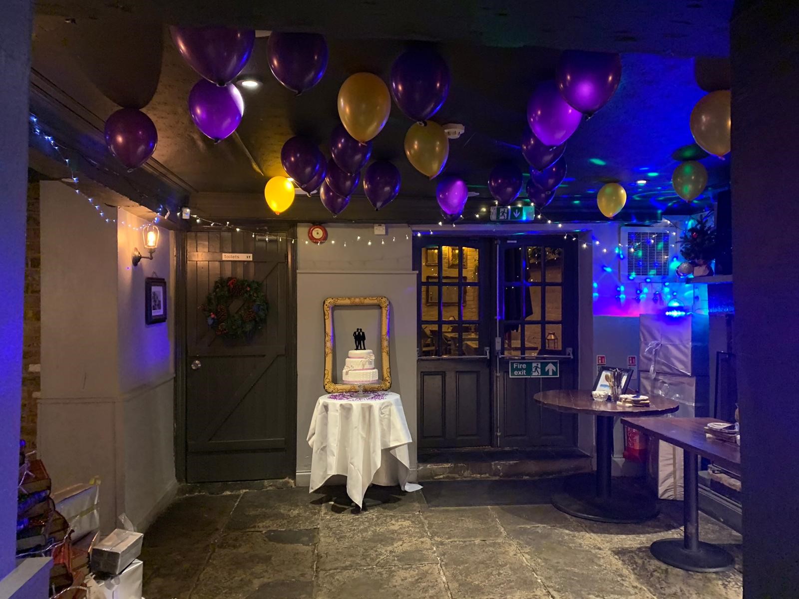 Festive garden room with purple and gold balloons for birthday or anniversary celebrations.