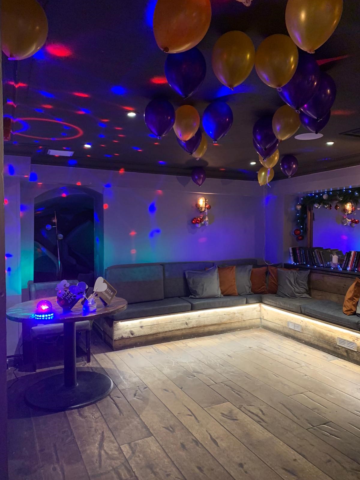 Vibrant event space in The Princess of Wales with cozy seating and colorful balloons.