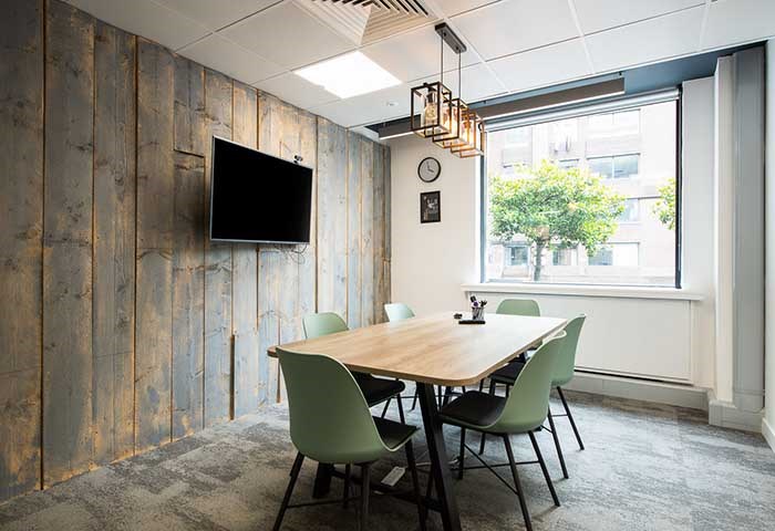 Cessna meeting room with wooden table and green chairs, perfect for team brainstorming sessions.