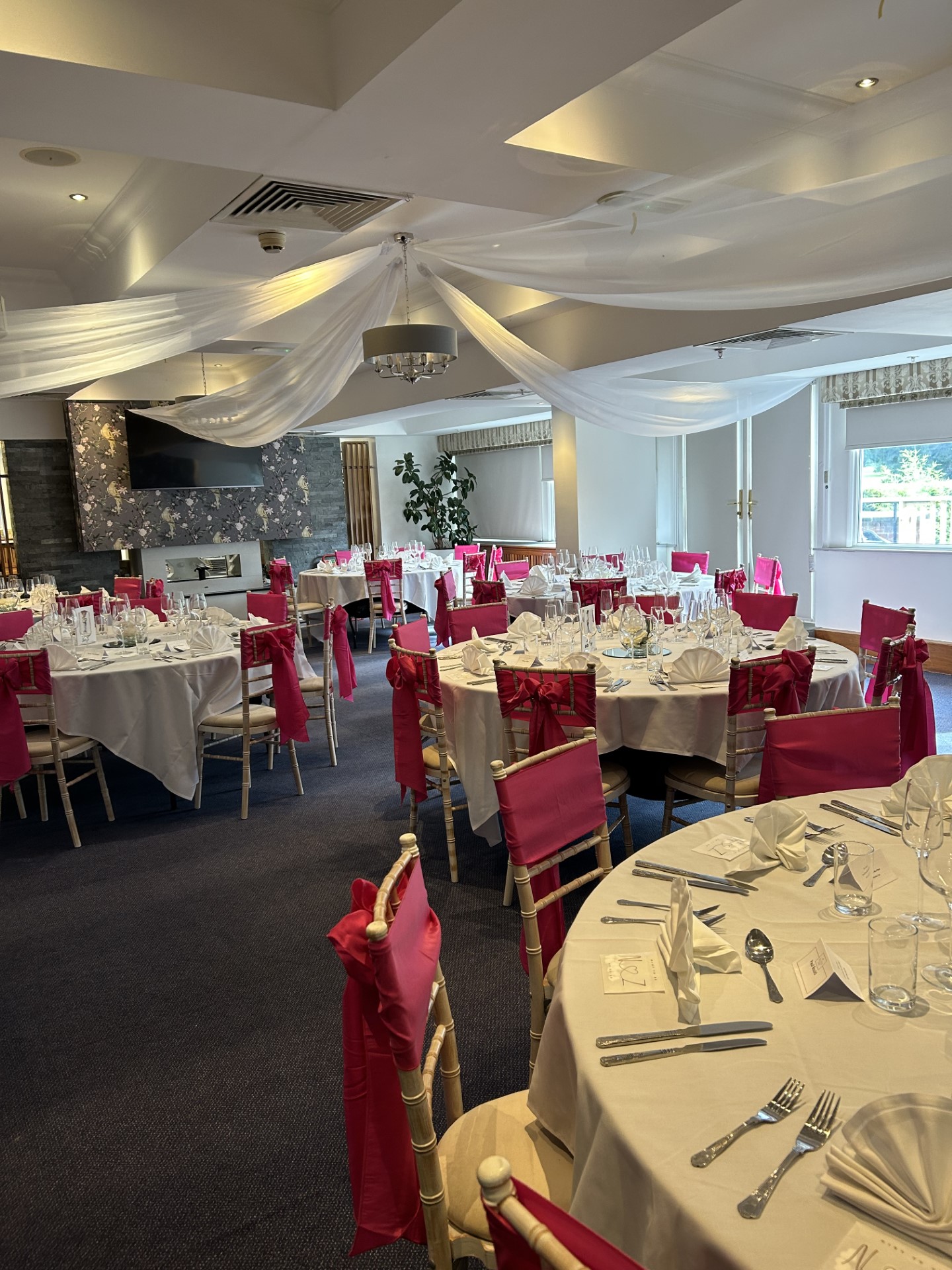Elegant event space at Meon Valley Hotel with pink chair sashes, perfect for weddings.