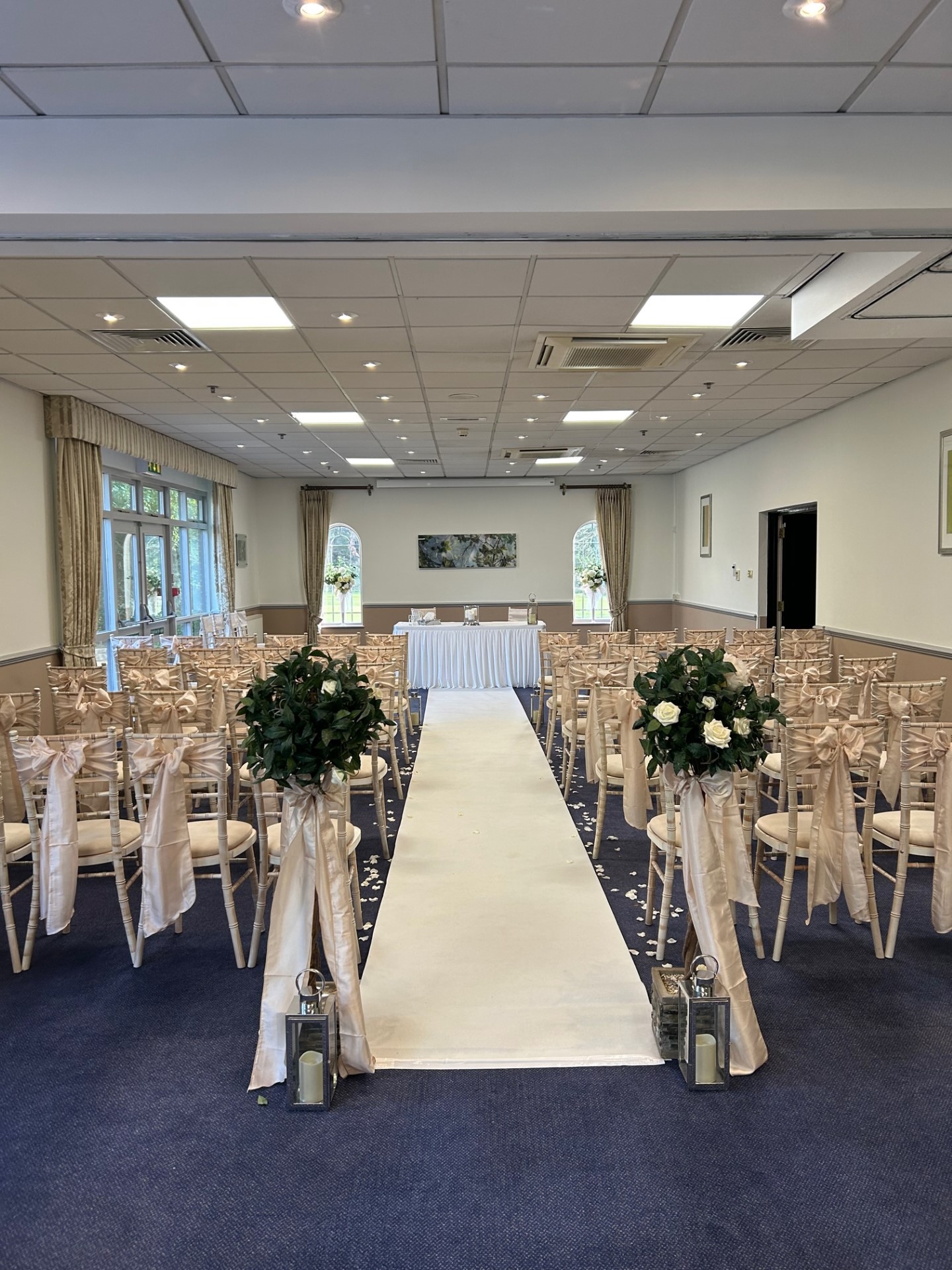 Elegant wedding setup at Meon Valley Hotel with floral arrangements and soft fabric sashes.