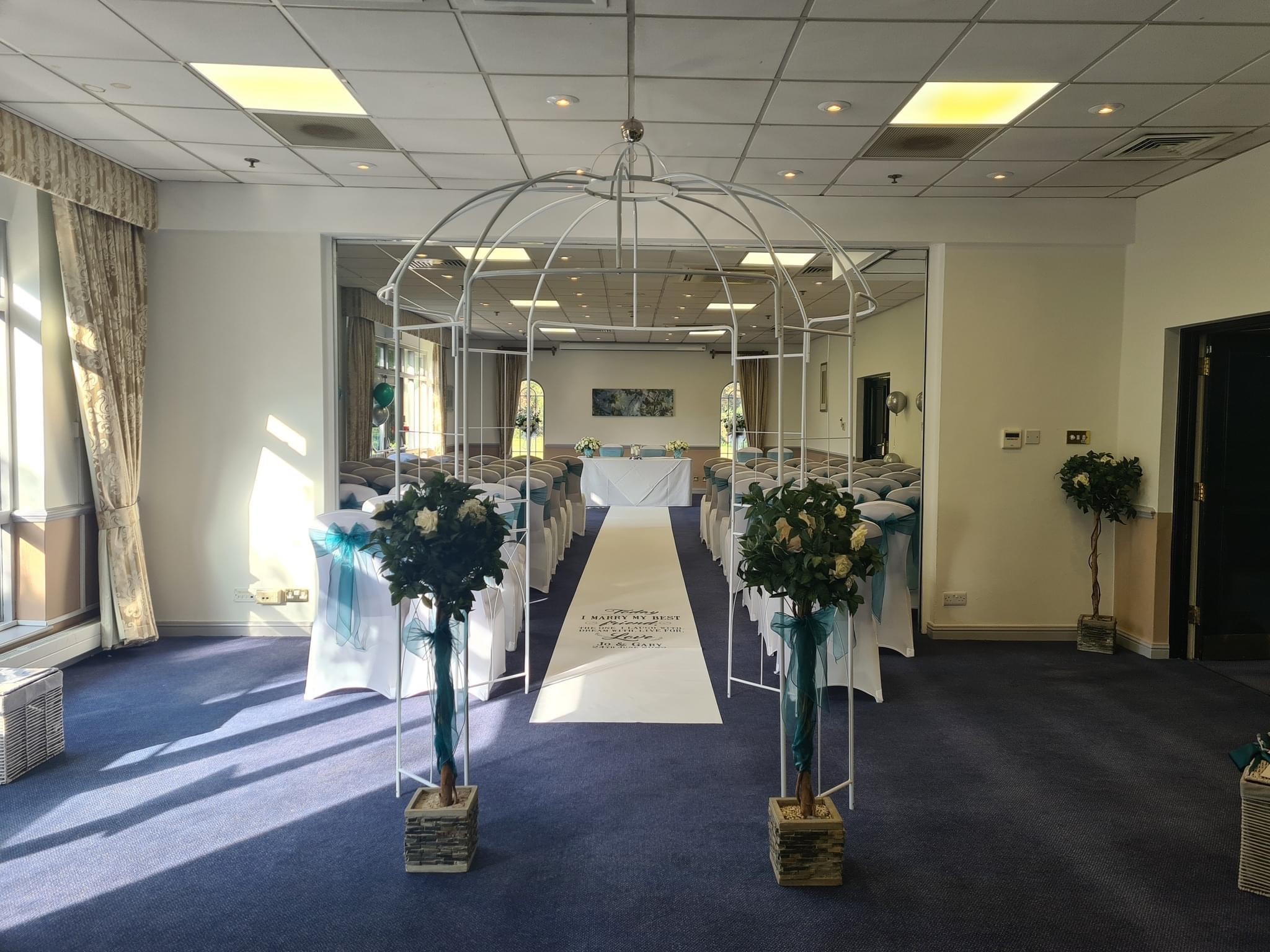 Elegant wedding ceremony setup at Meon Valley Hotel with floral arrangements and archway.