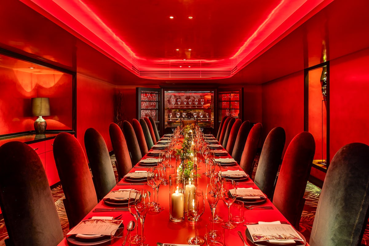 Private dining room at The Mandrake with red decor for upscale corporate events.