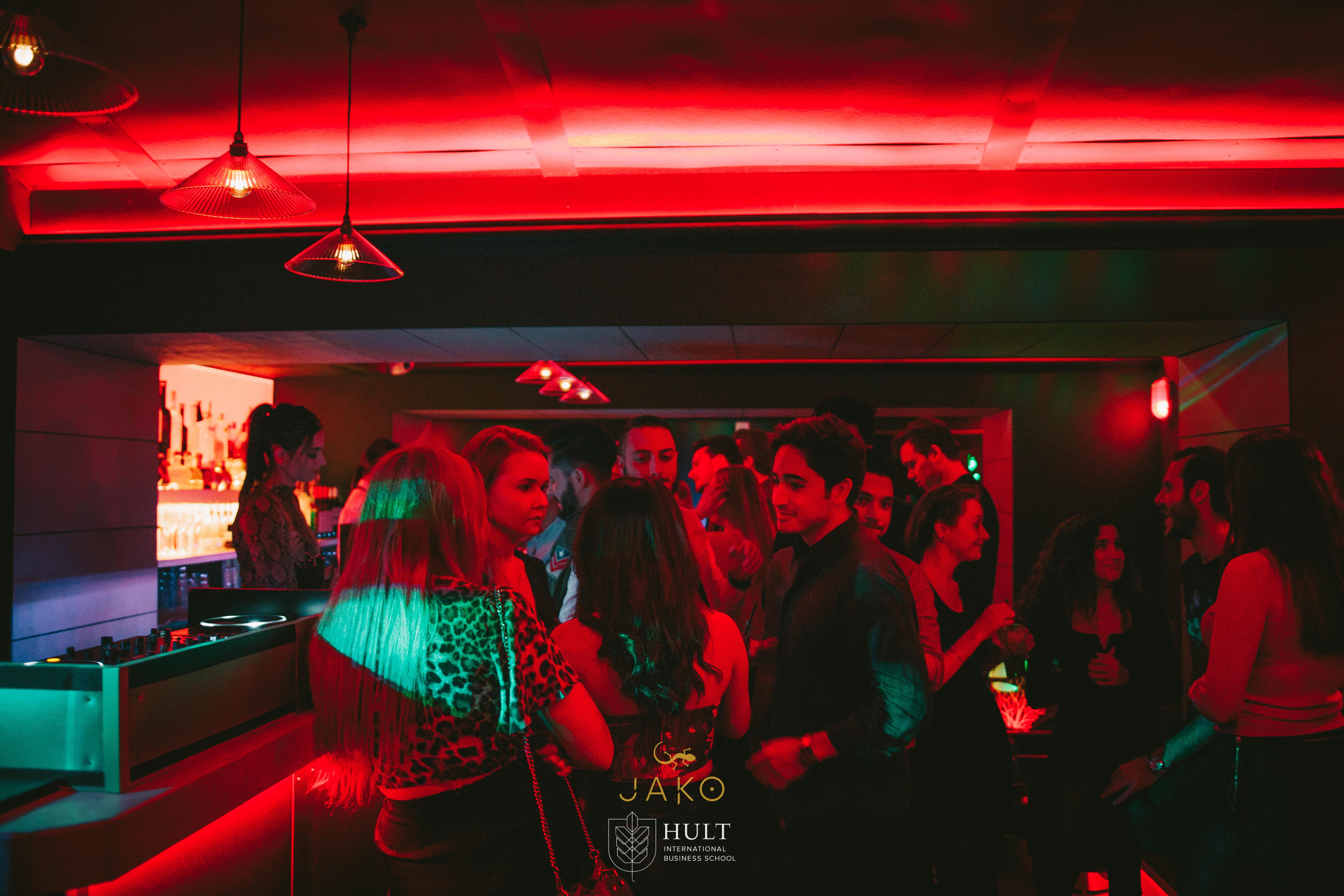 Vibrant networking event in Club Royale London with dynamic red lighting.