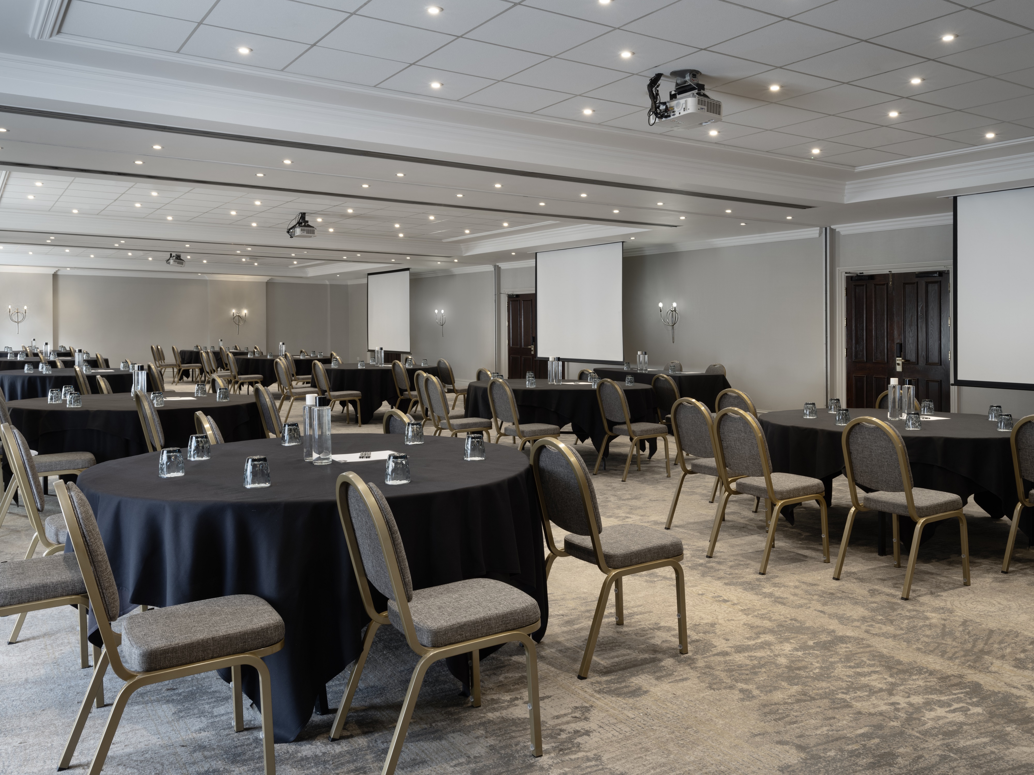 Worsley Suite meeting space with round tables, ideal for corporate events and conferences.