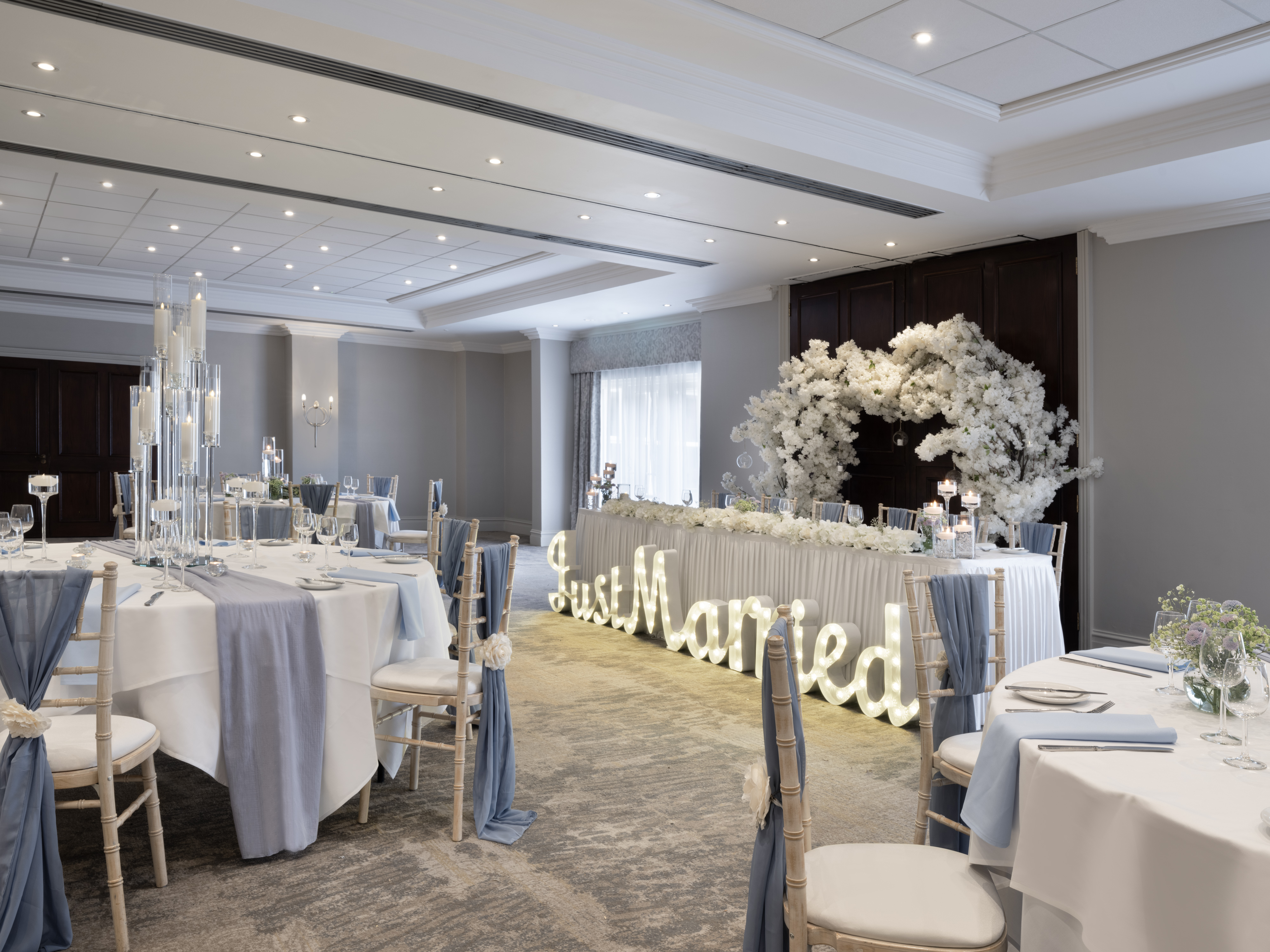 Elegant wedding reception in Worsley Suite with blue accents and floral decor.