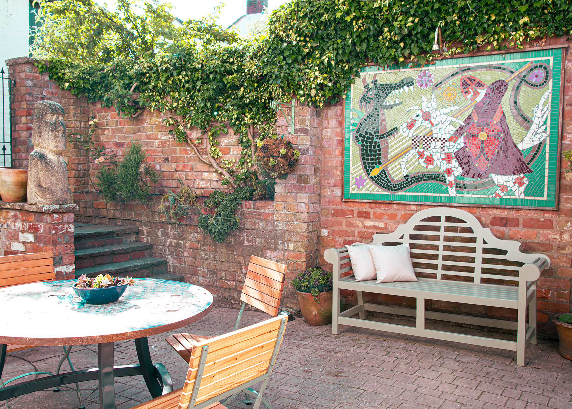 Charming outdoor space at The George Cafe with vibrant mosaic for networking events.