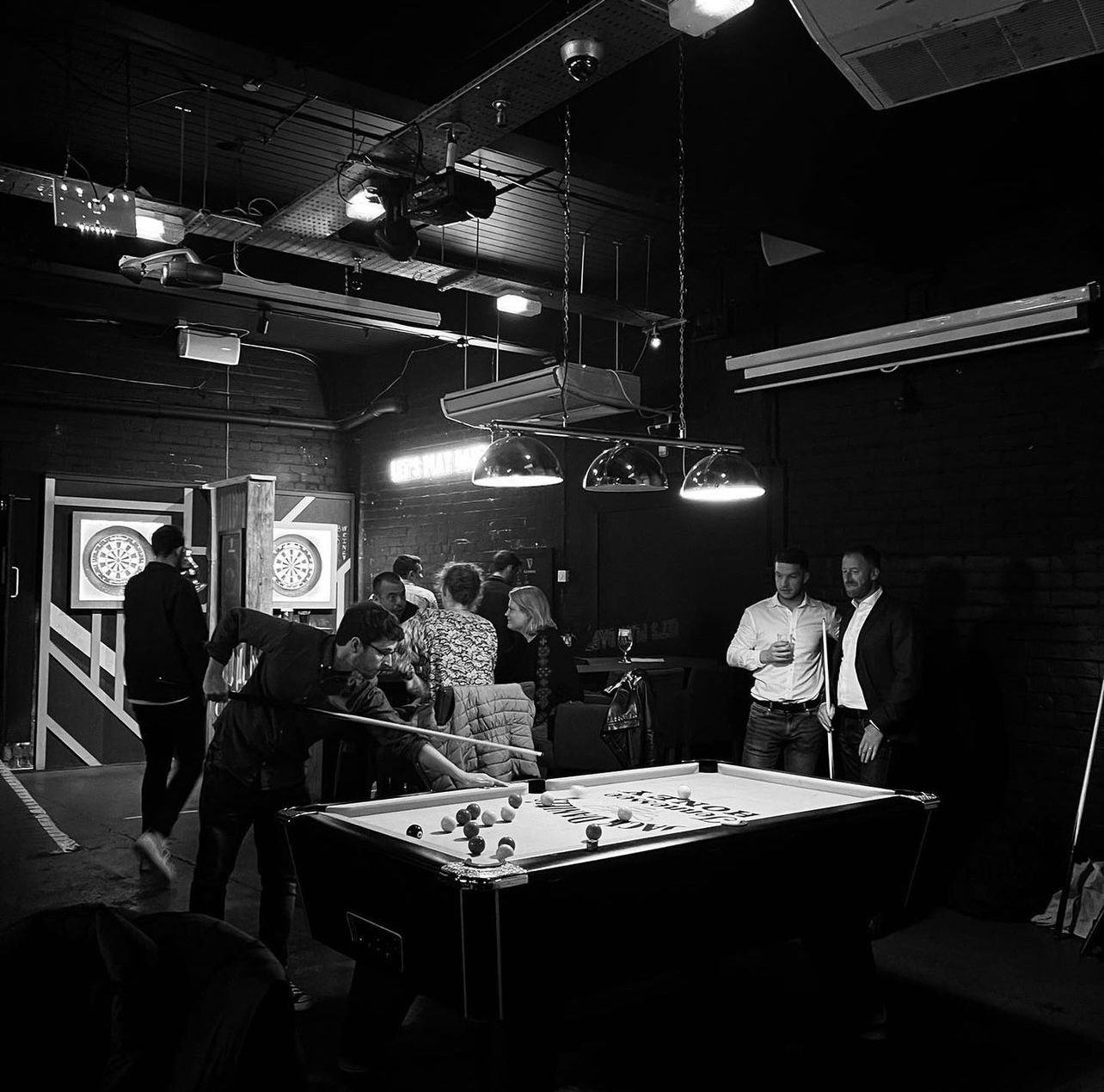 Vibrant networking event at Shack Bar with pool table and dartboards.
