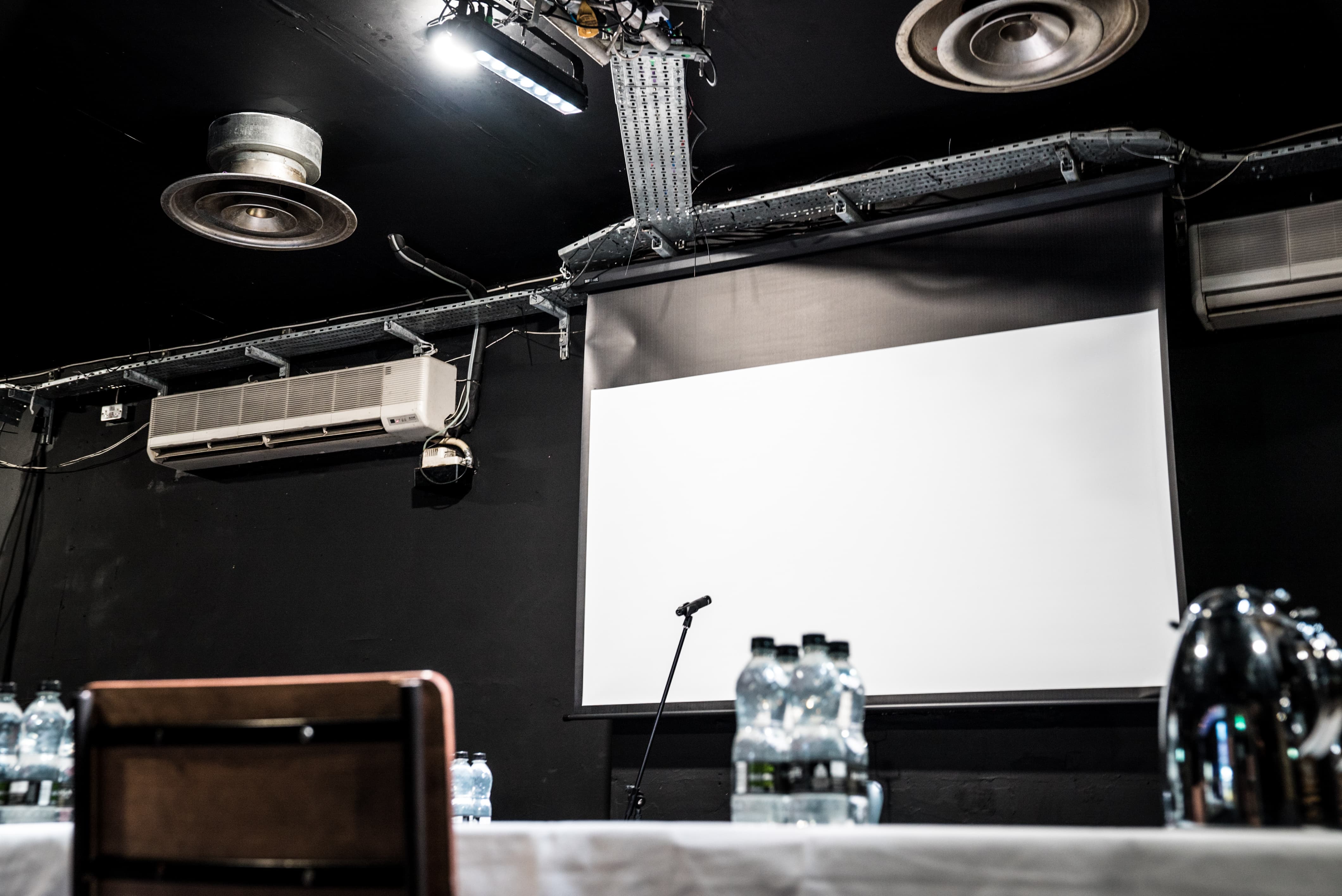 Corporate hire room in Brixton Jamm with projection screen for meetings and workshops.
