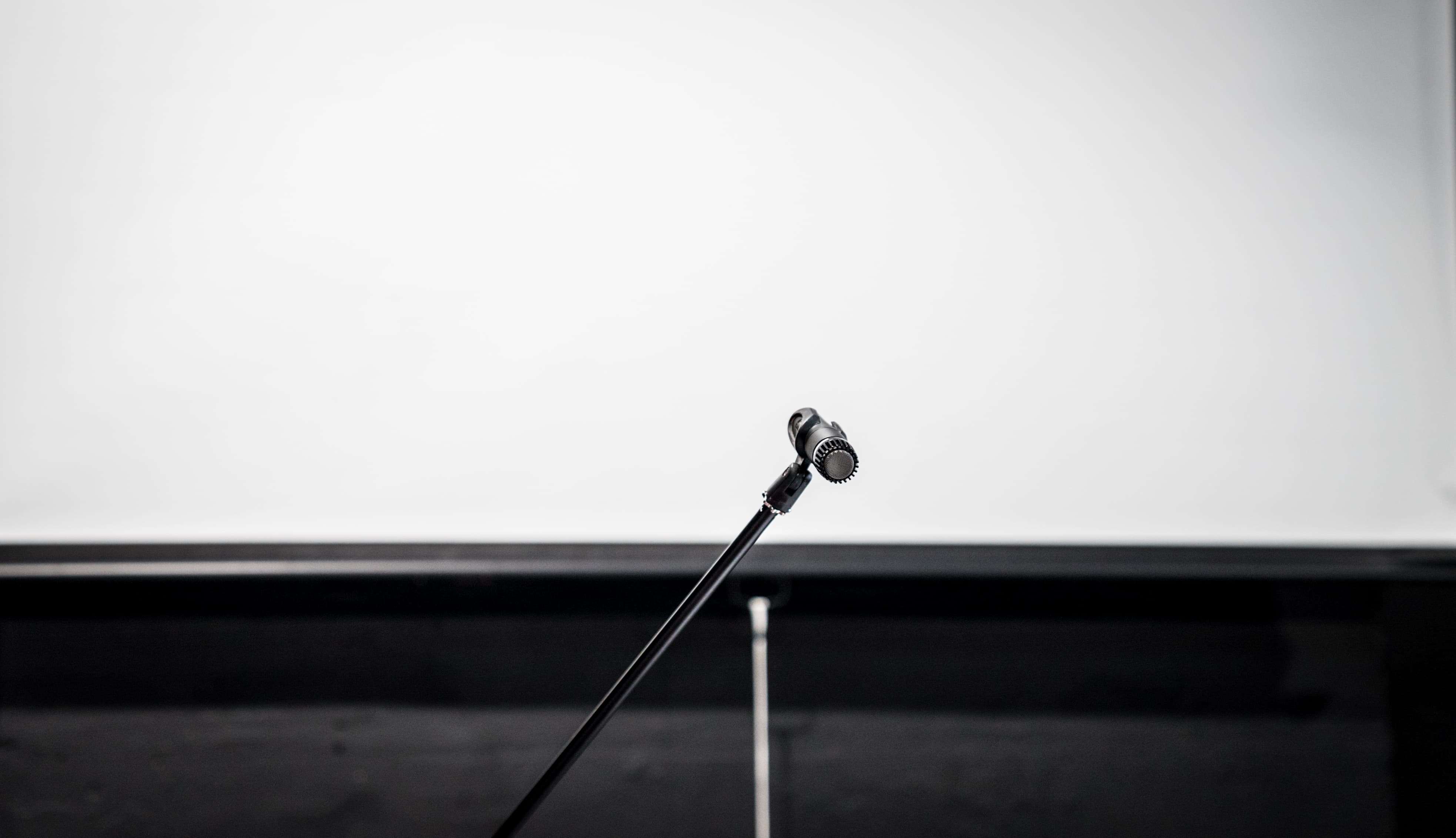 Corporate hire room with microphone and blank screen for presentations in Brixton Jamm.