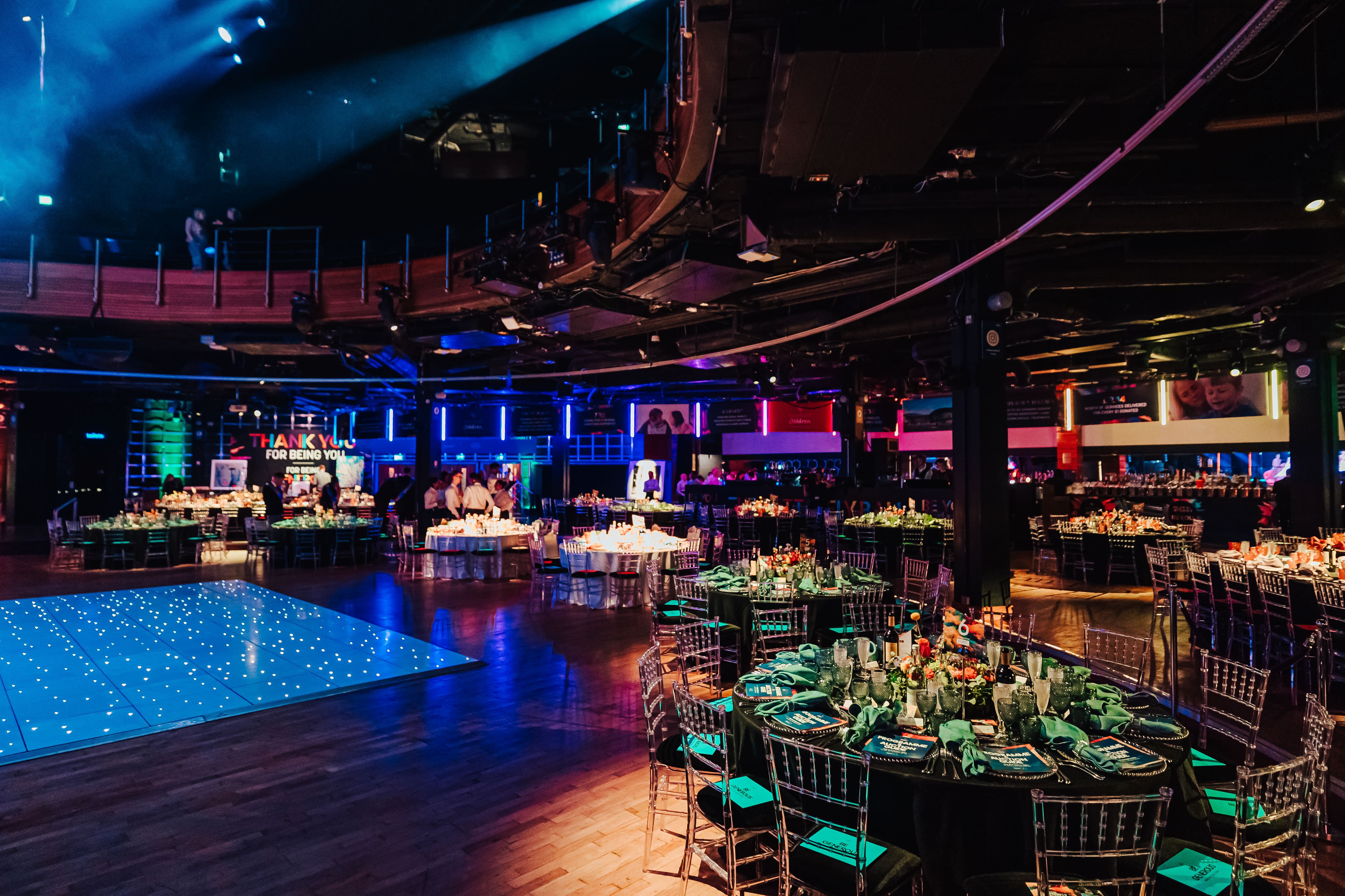 Gala event space at The O2 with floral centerpieces and twinkling lights.