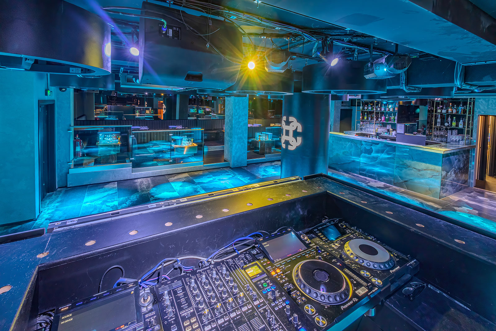 Modern event space with DJ booth, vibrant lighting for parties and corporate events.