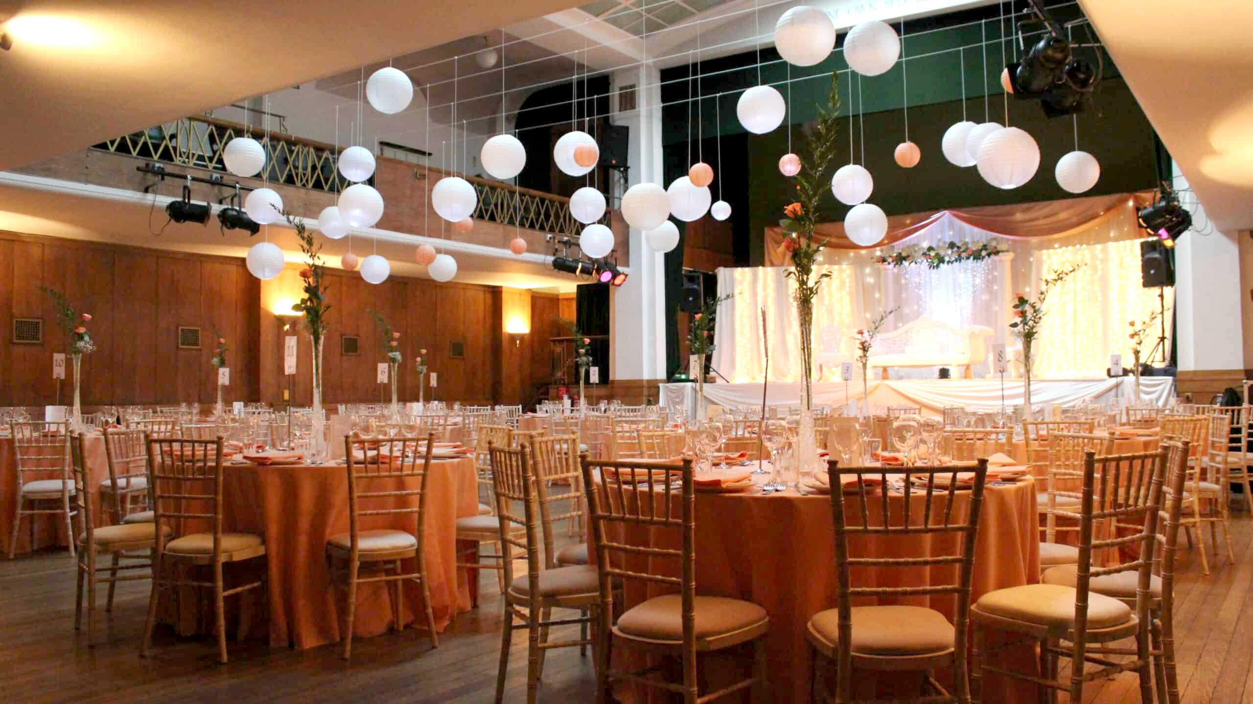 Elegant wedding venue in Conway Hall with orange linens and gold chairs.