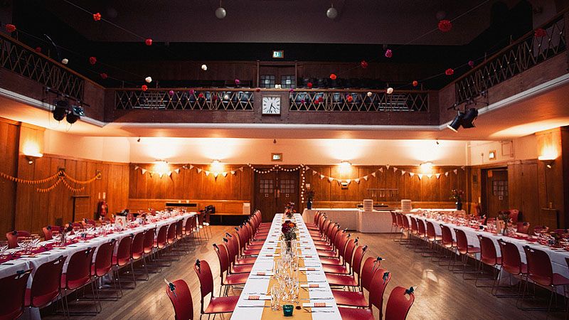 Elegant wedding setup in Conway Hall with red accents and lanterns for a formal dinner.