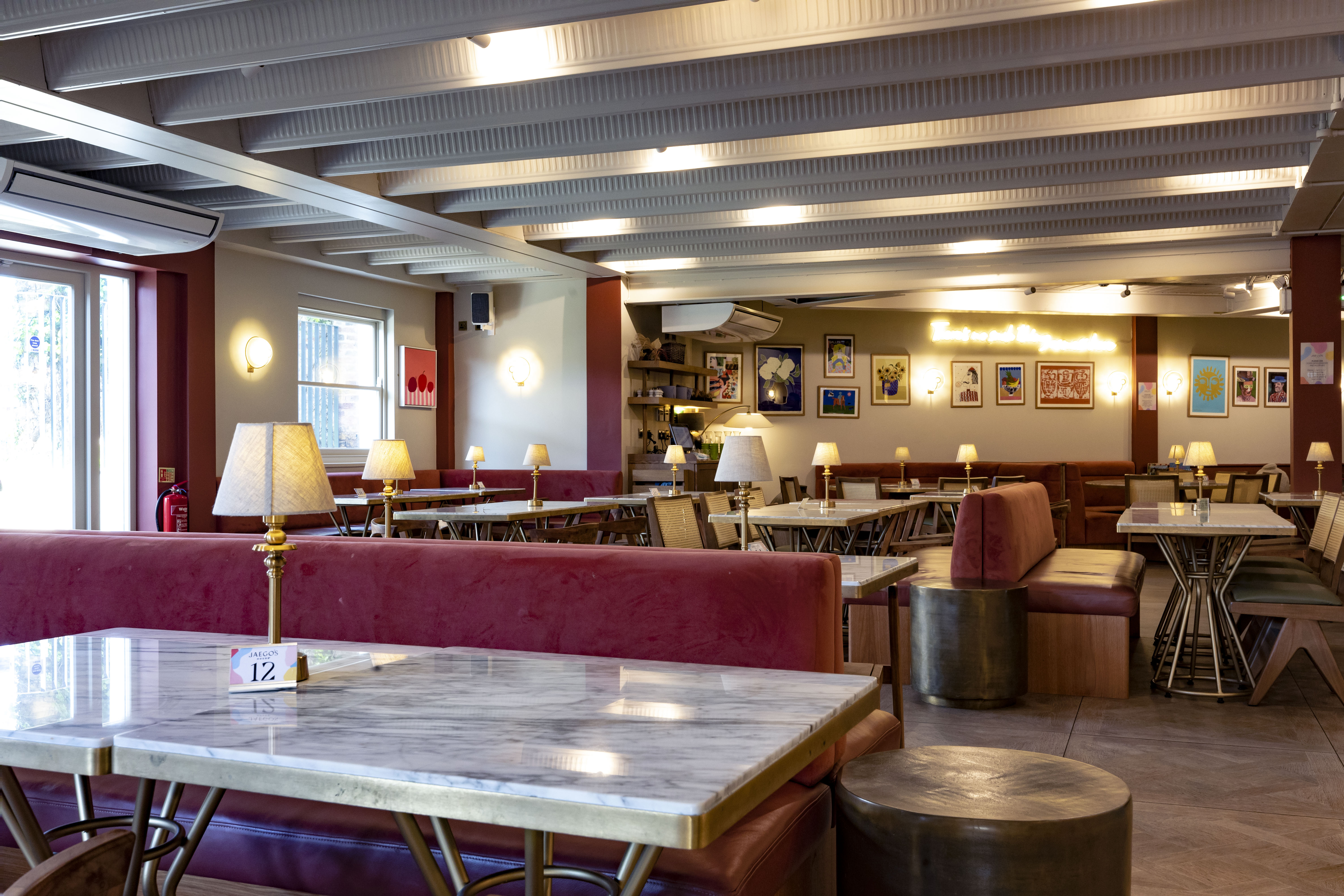 Stylish event space with cozy red banquettes, perfect for networking and gatherings.