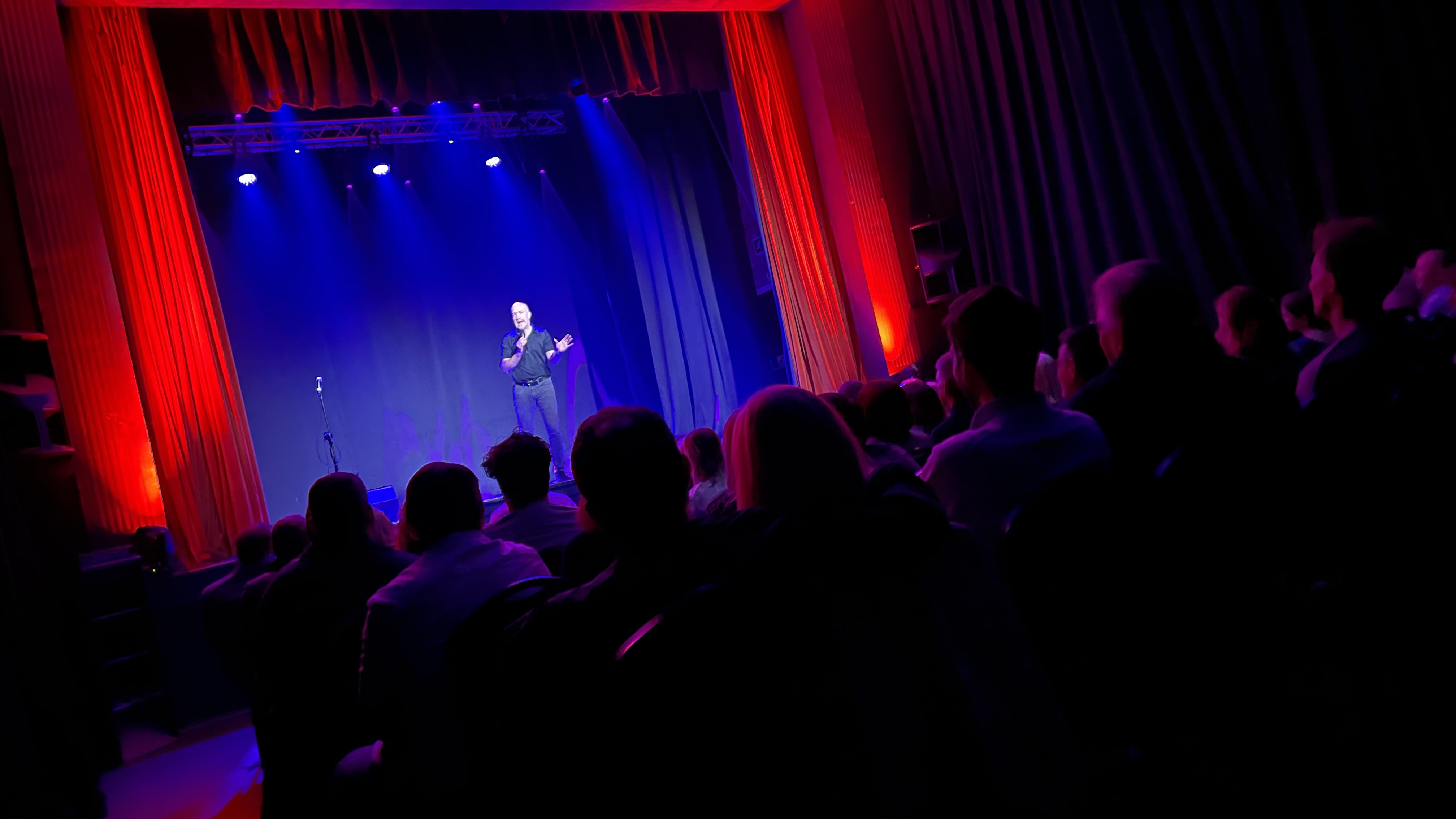 Esher Theatre stage with speaker, ideal for conferences and performances.