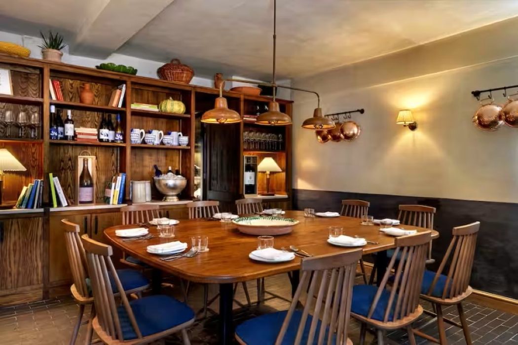 Adega Private Dining Room in Luso, featuring a wooden table for meetings and gatherings.