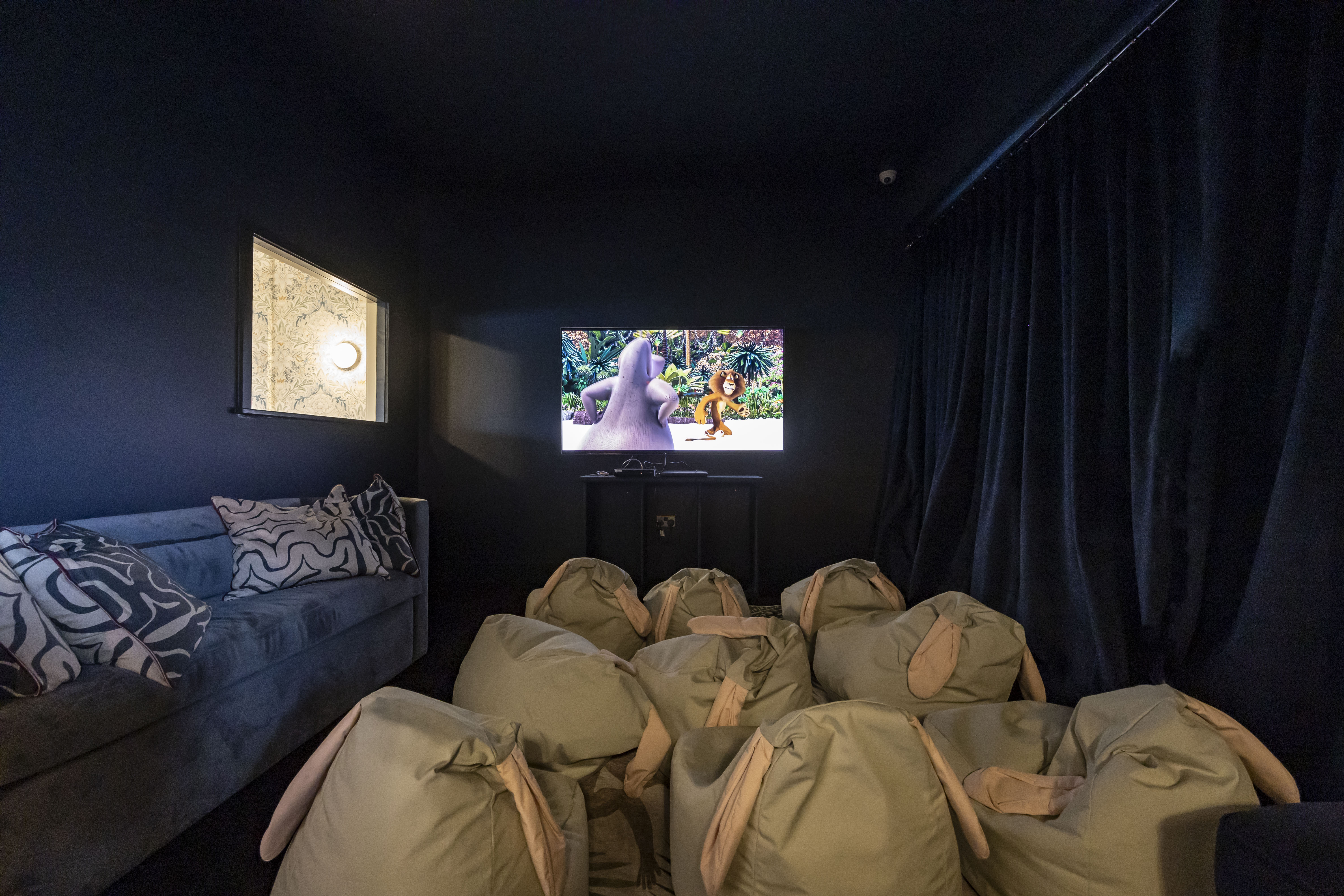Cozy living room cinema with plush seating for intimate gatherings and workshops.
