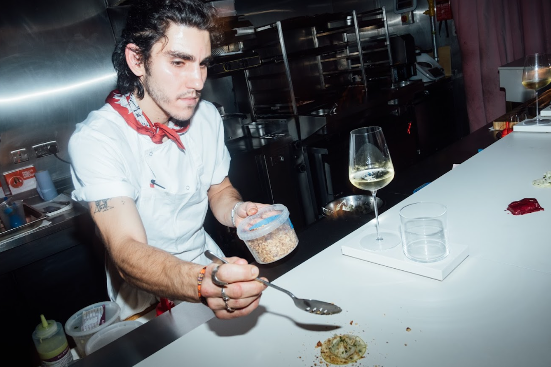 Chef plating gourmet kebabs in a vibrant kitchen for upscale dining events.