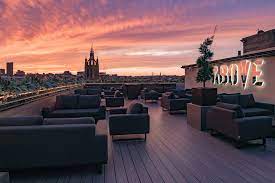 Stunning Above Rooftop venue in Newcastle with modern seating and sunset backdrop for events.