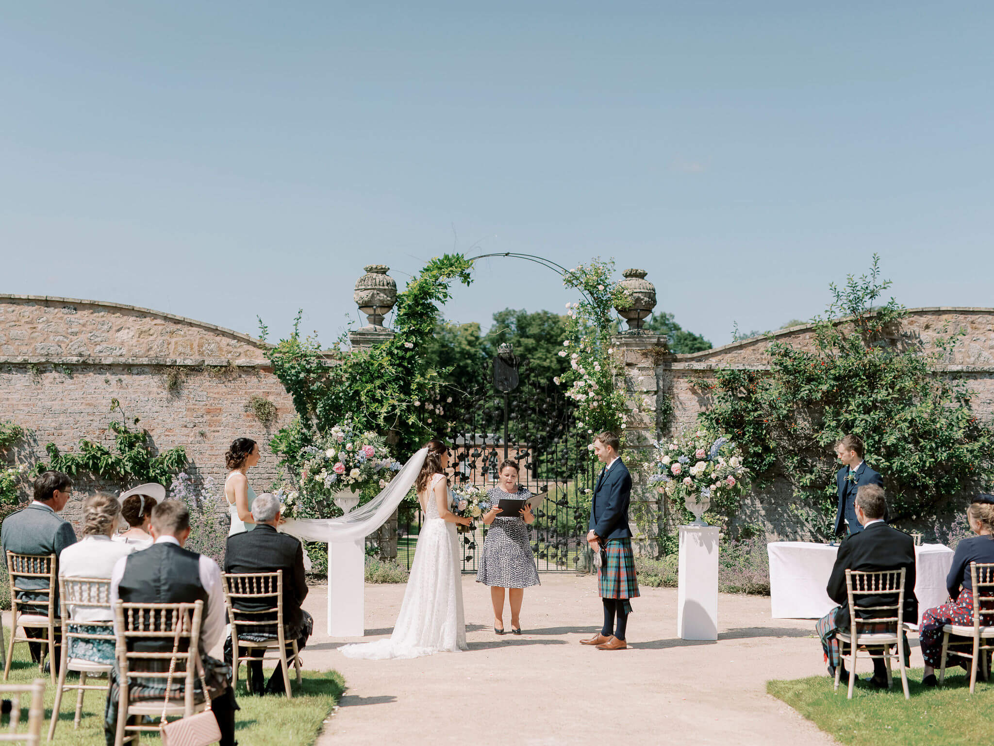 Georgian Walled Garden wedding with floral arch and elegant seating for guests.