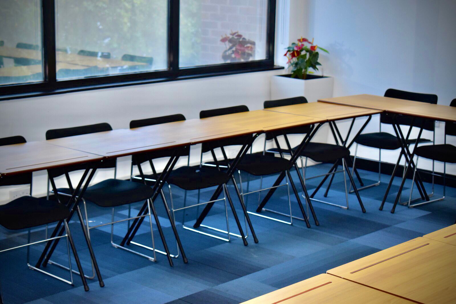 "Flexible meeting space with folding tables in Stratford, London for workshops and events."