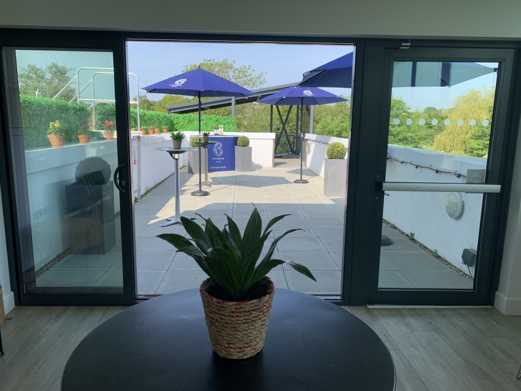 The Long Room at Guildford Pavilion, stylish outdoor event space with umbrellas.