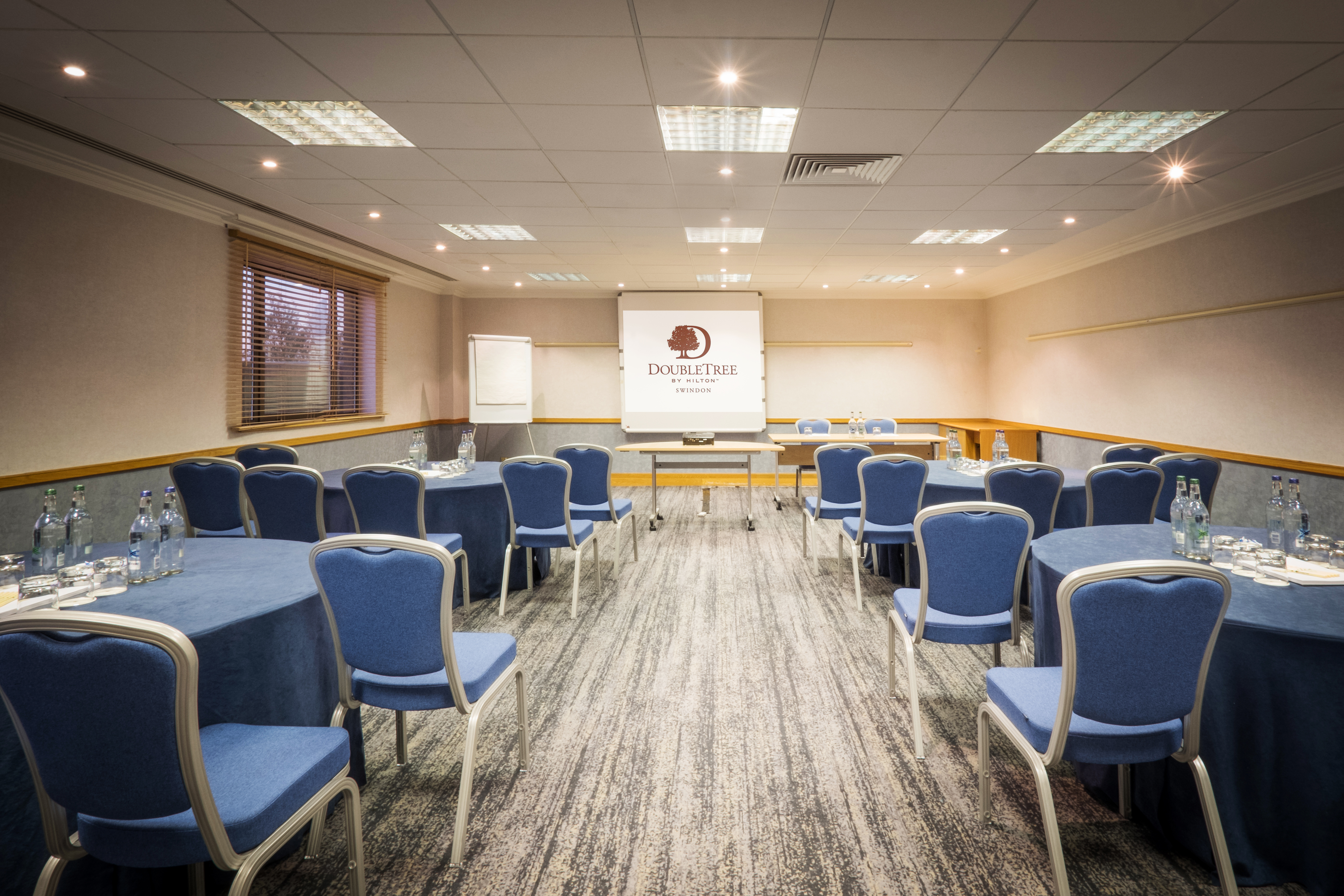 Hawksworth Suite meeting room with round tables, ideal for workshops and conferences.