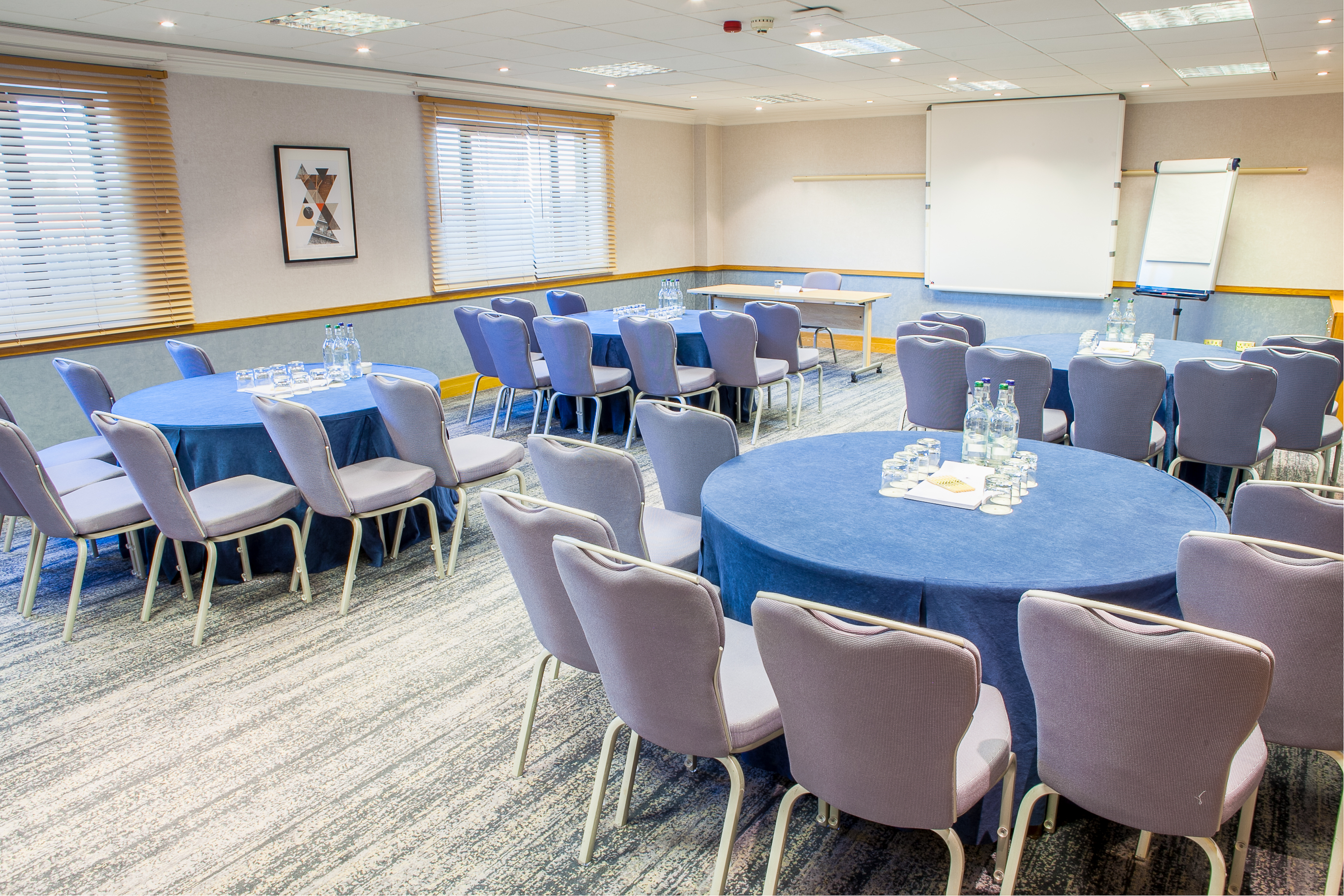 Hawksworth Suite meeting room with circular tables, ideal for professional events and networking.