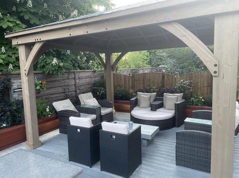 Stylish outdoor seating area under a gazebo for casual meetings and networking events.