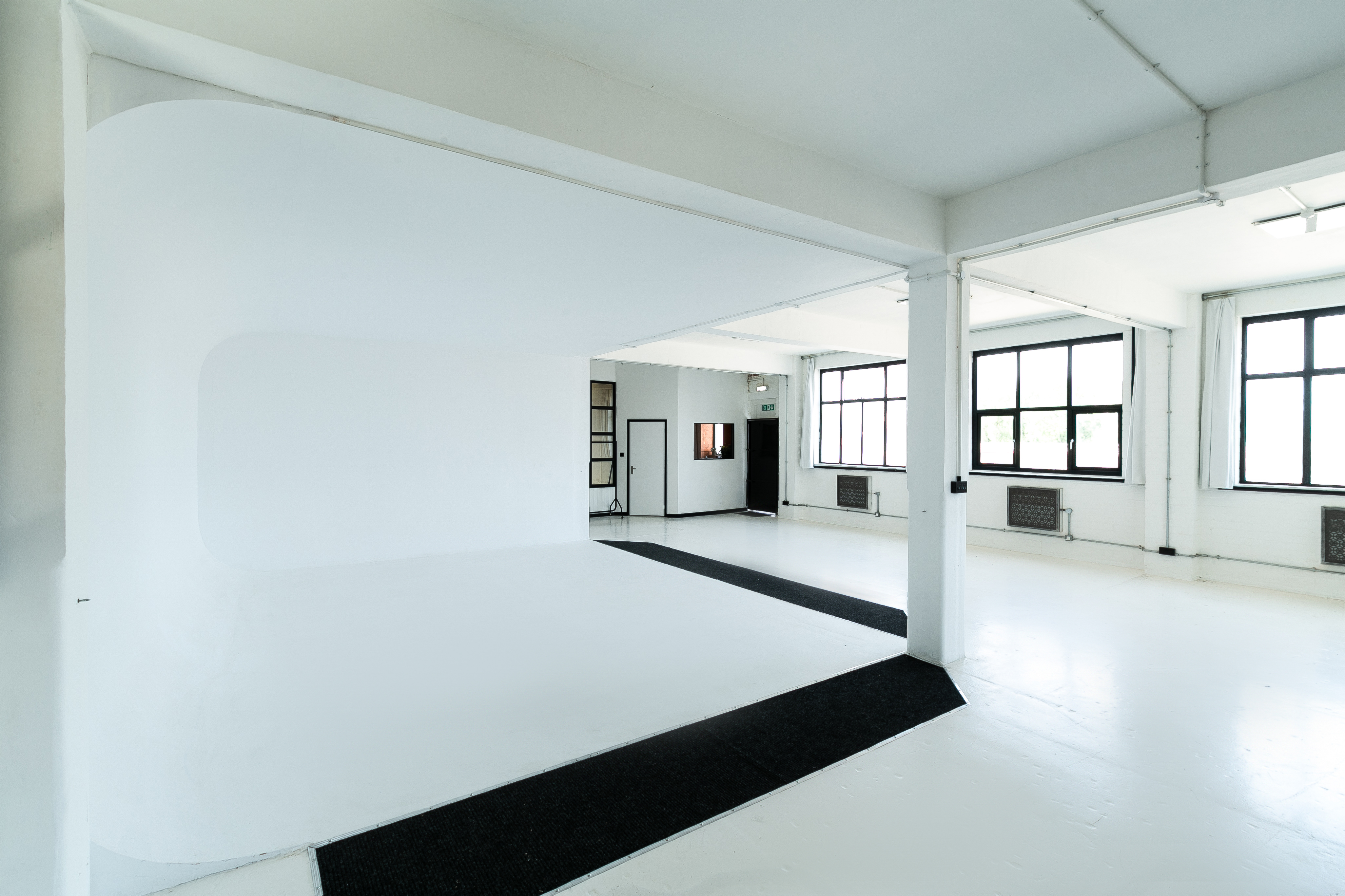 Versatile minimalist event space with natural light for workshops and presentations.