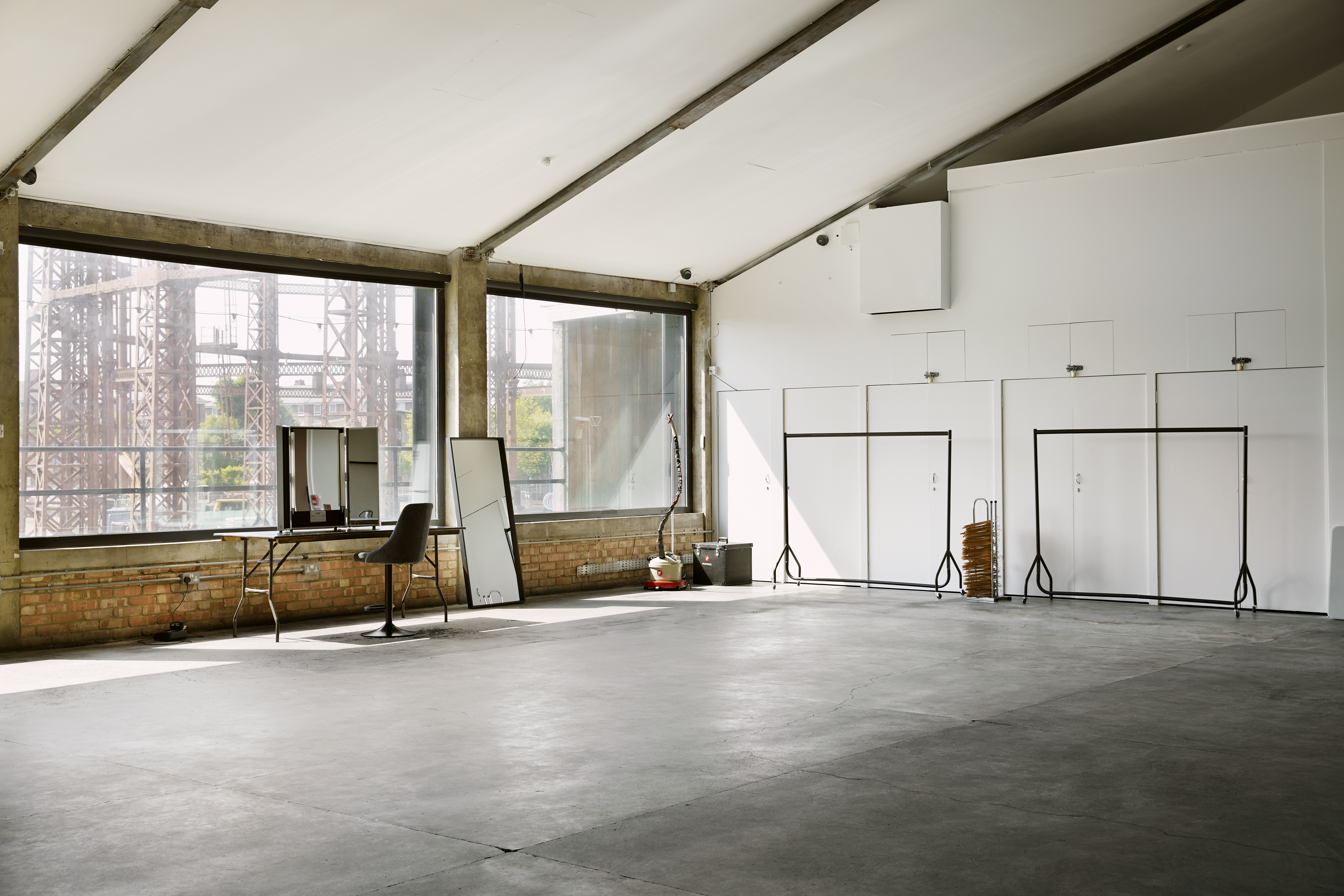 Spacious industrial venue with large windows for corporate events and social gatherings.