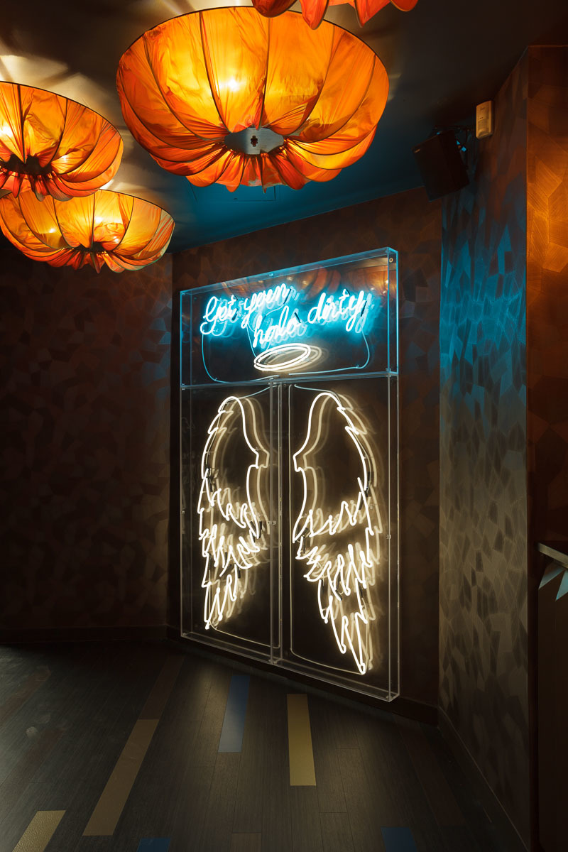 Neon angel wings sign at Ground Floor Bar, perfect for themed parties and events.