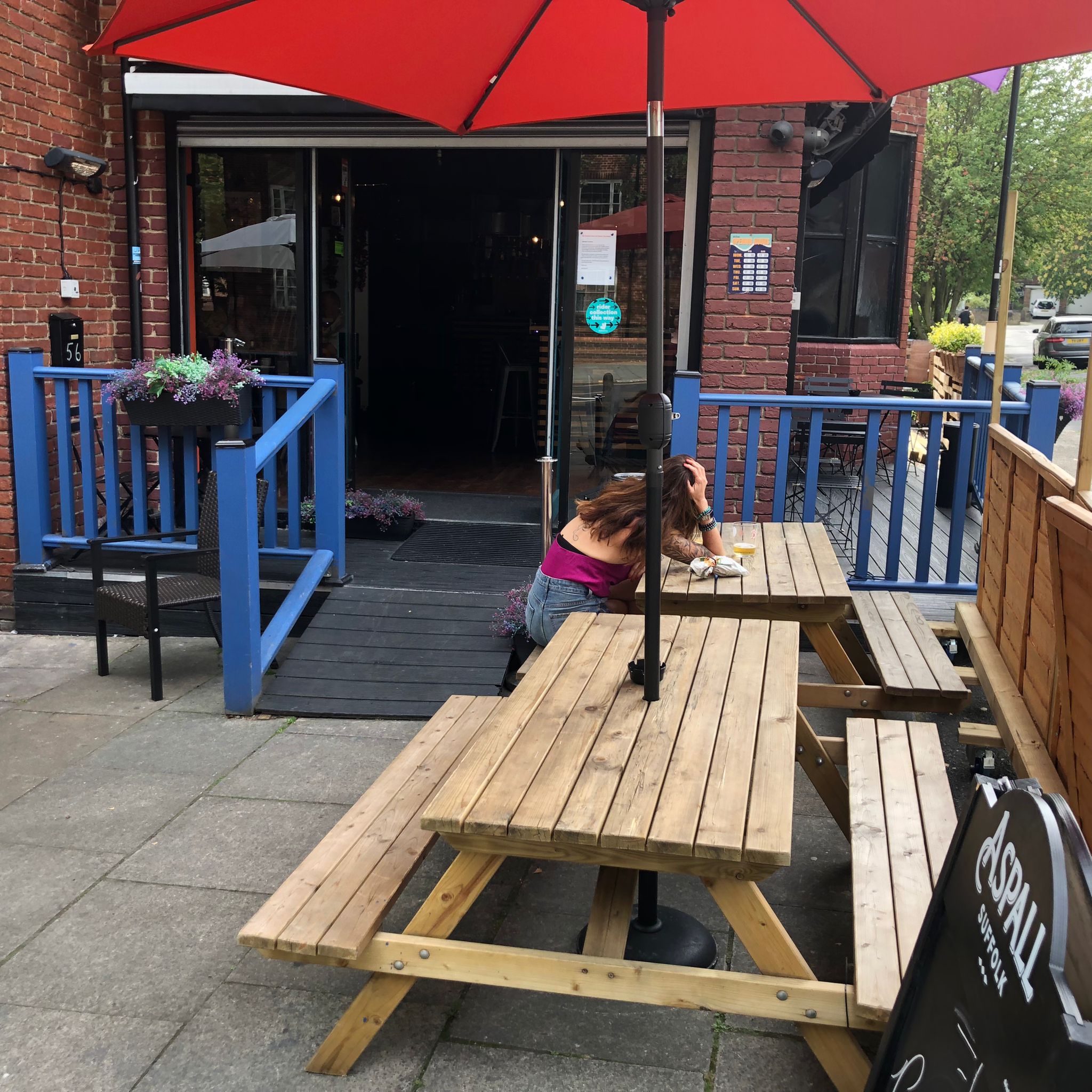 Outdoor seating at Neptune Bar with wooden tables and vibrant blue accents for casual events.