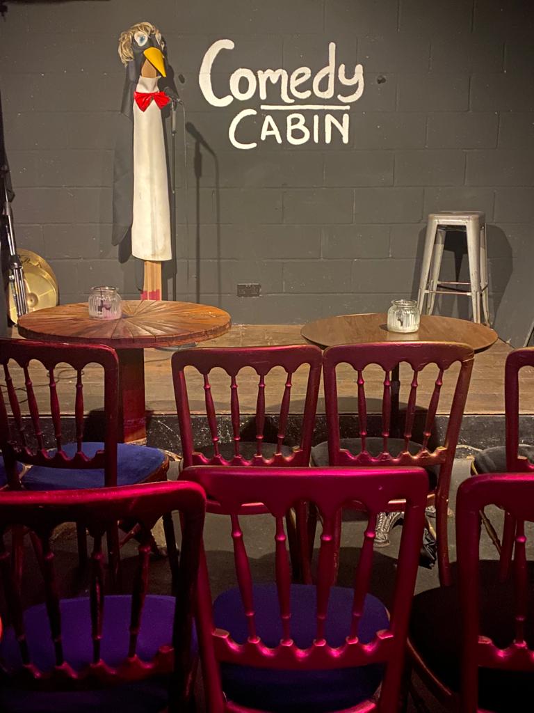 Cozy Hoxton Cabin Basement with candlelit tables for intimate gatherings and performances.