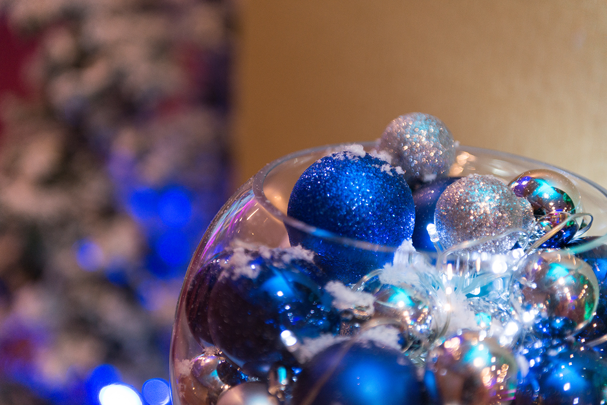 "Blue and silver ornaments in glass bowl for London Suite Christmas party decor."